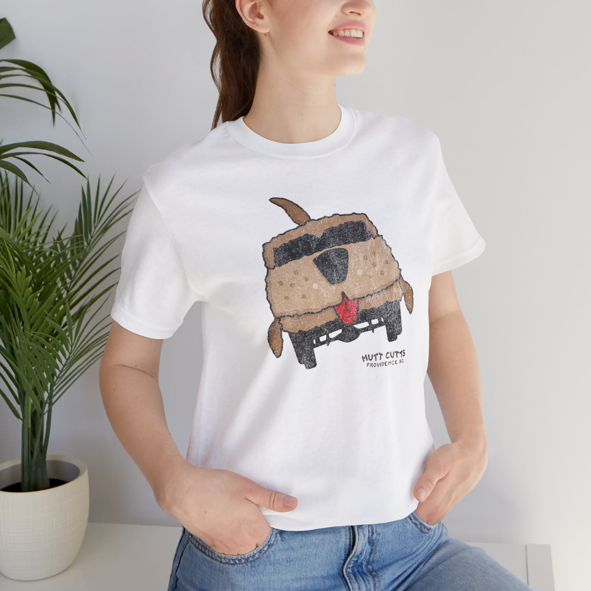 Woman wearing white Bella+Canvas tee with vintage Mutt Cutts dog van graphic inspired by Dumb and Dumber movie.
