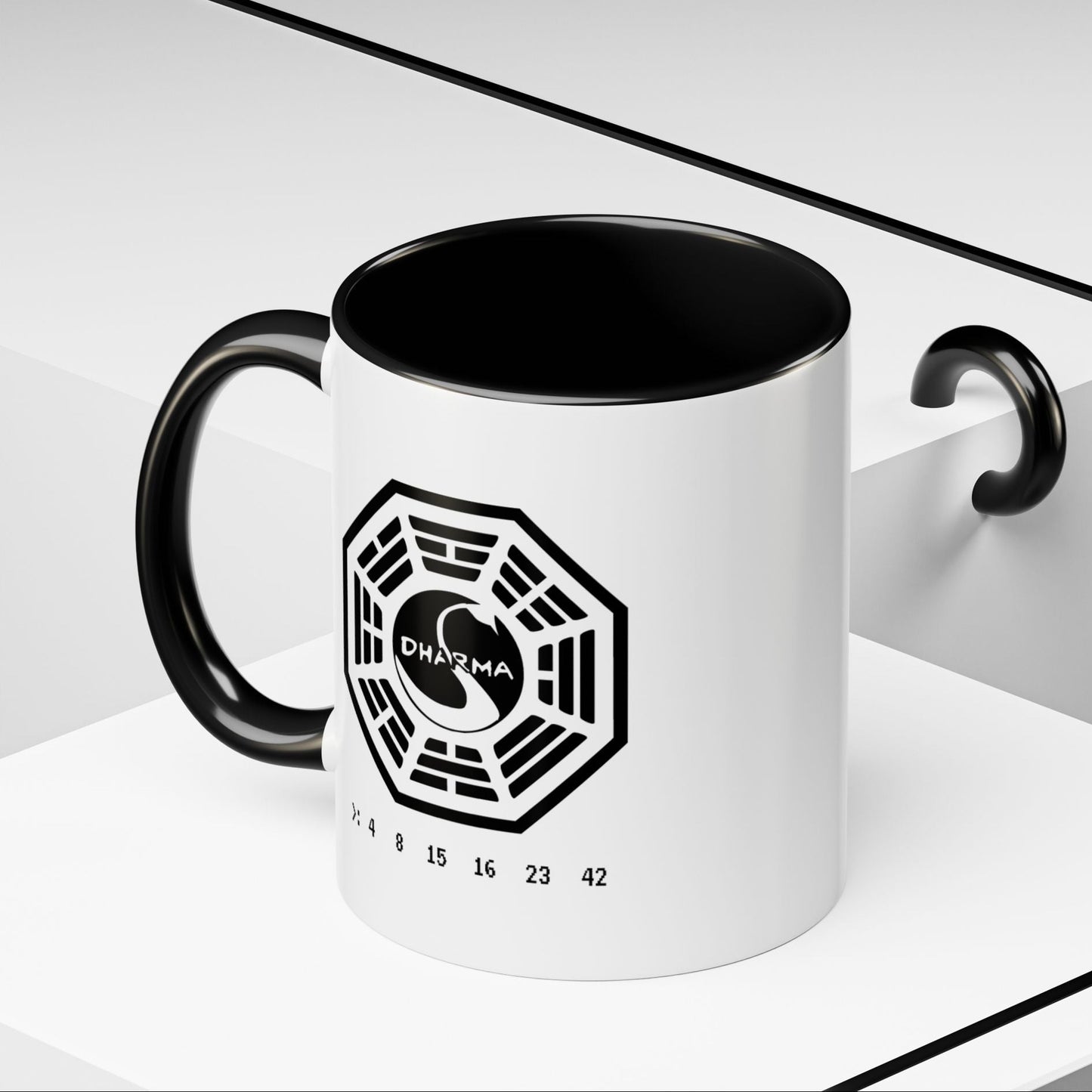 Angled view of 11 oz White ceramic Dharma Initiative Swan Station logo mug with black handle and interior, hatch numbers 4 8 15 16 23 42
