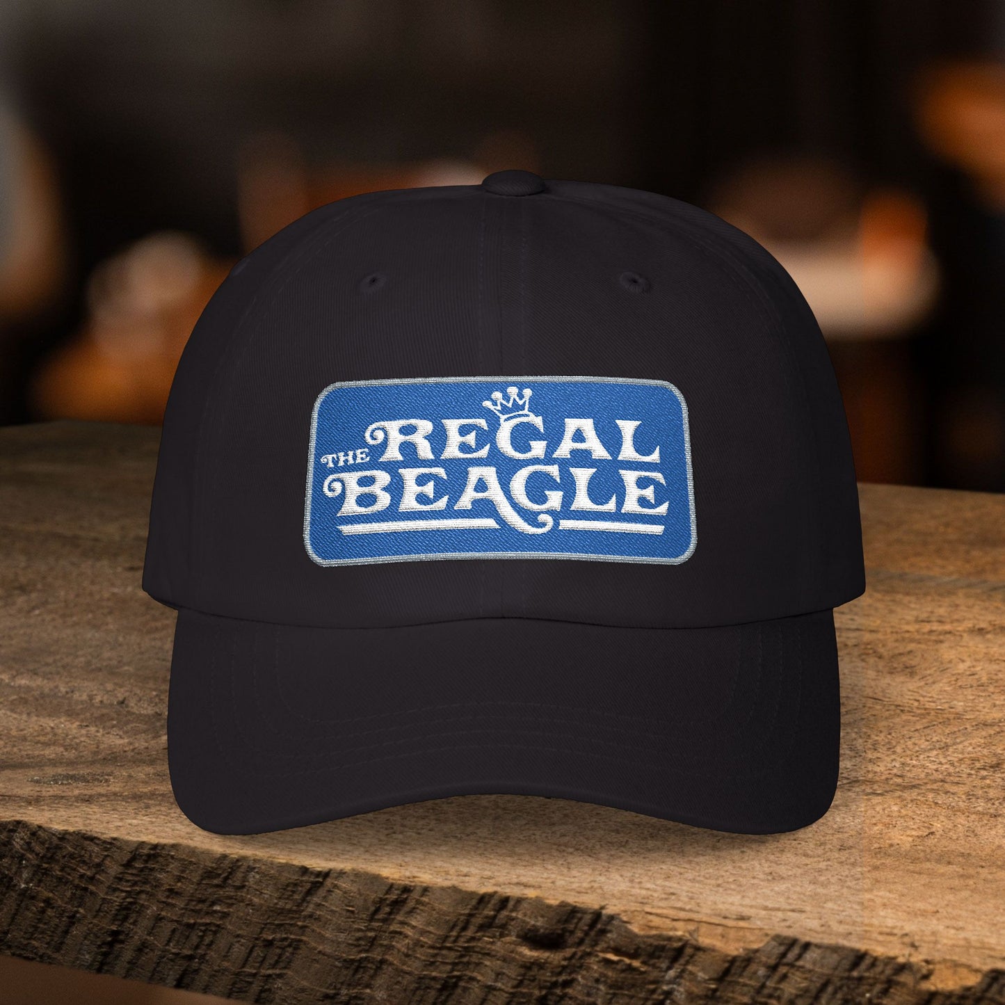 Black dad cap with embroidered Regal Beagle patch logo, Three's Company inspired fictional bar merch
