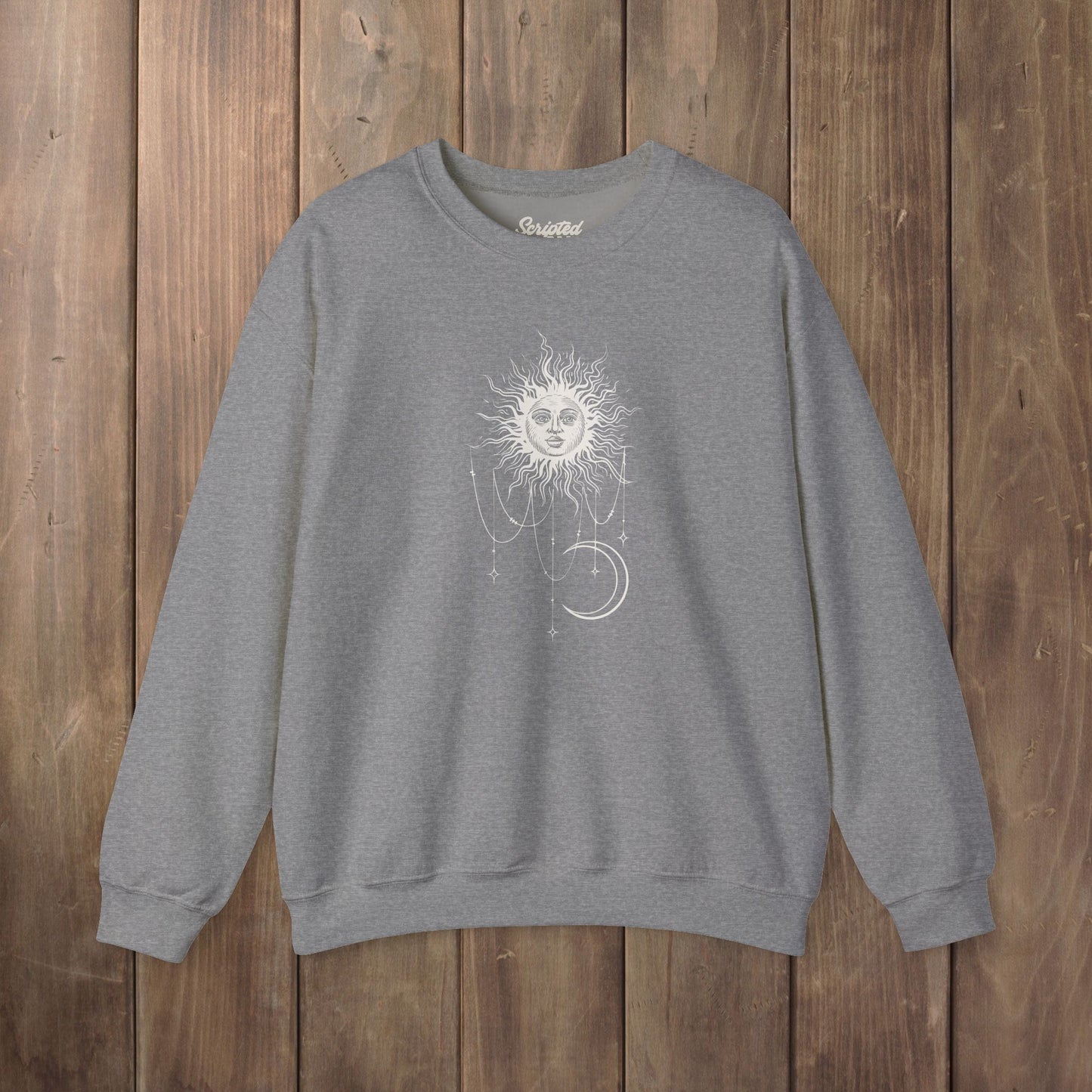 Heather gray crewneck sweatshirt with boho celestial sun face, stars, and crescent moon design worn by Patricia in Widow's Bay