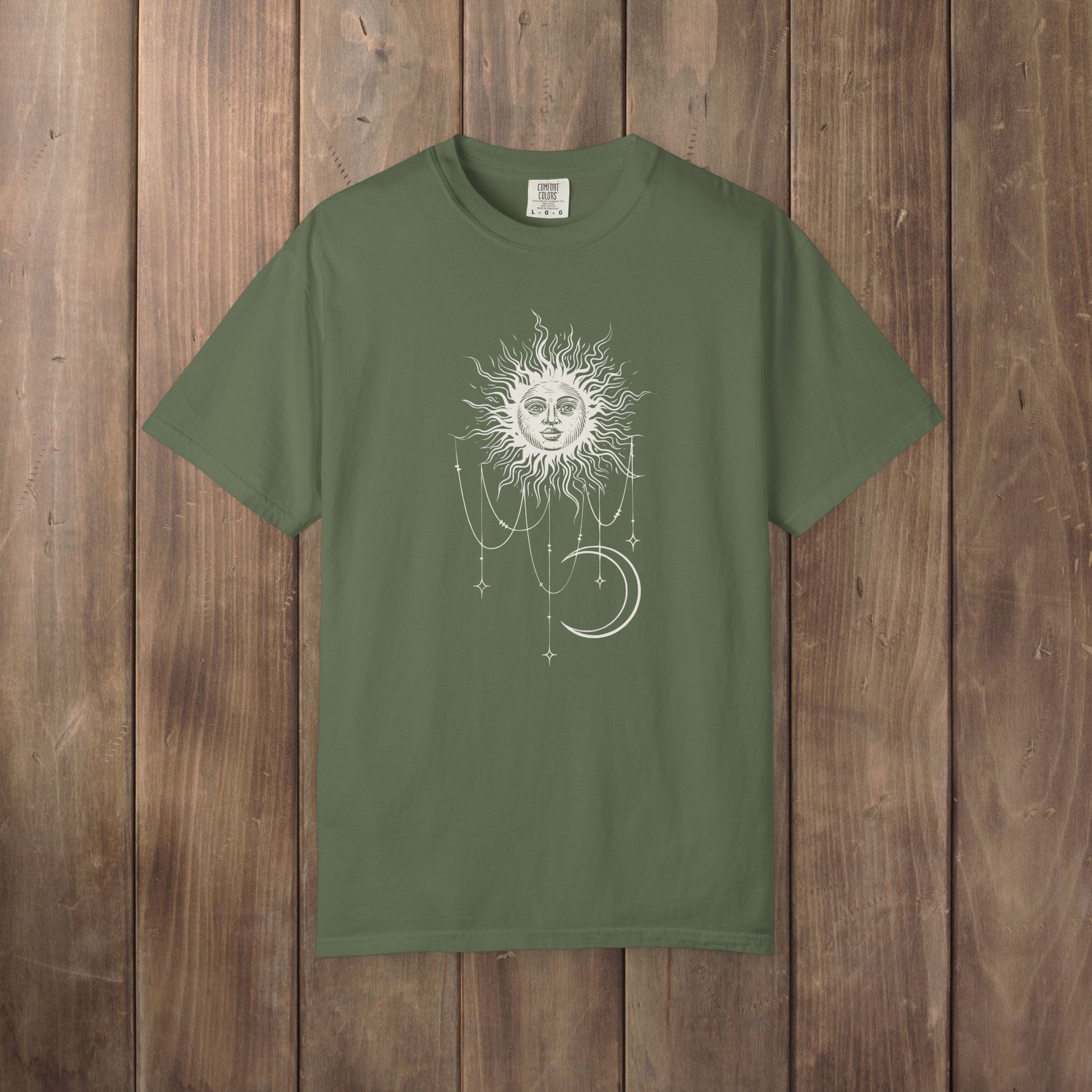 Sage green Comfort Colors tee with a celestial sun and crescent moon design, worn by Patricia in Widow's Bay S1E8