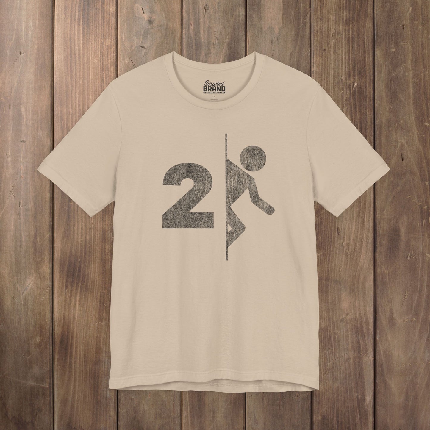 Tan tee with vintage distressed Portal 2 partial logo figure diving through a portal, aperture labs