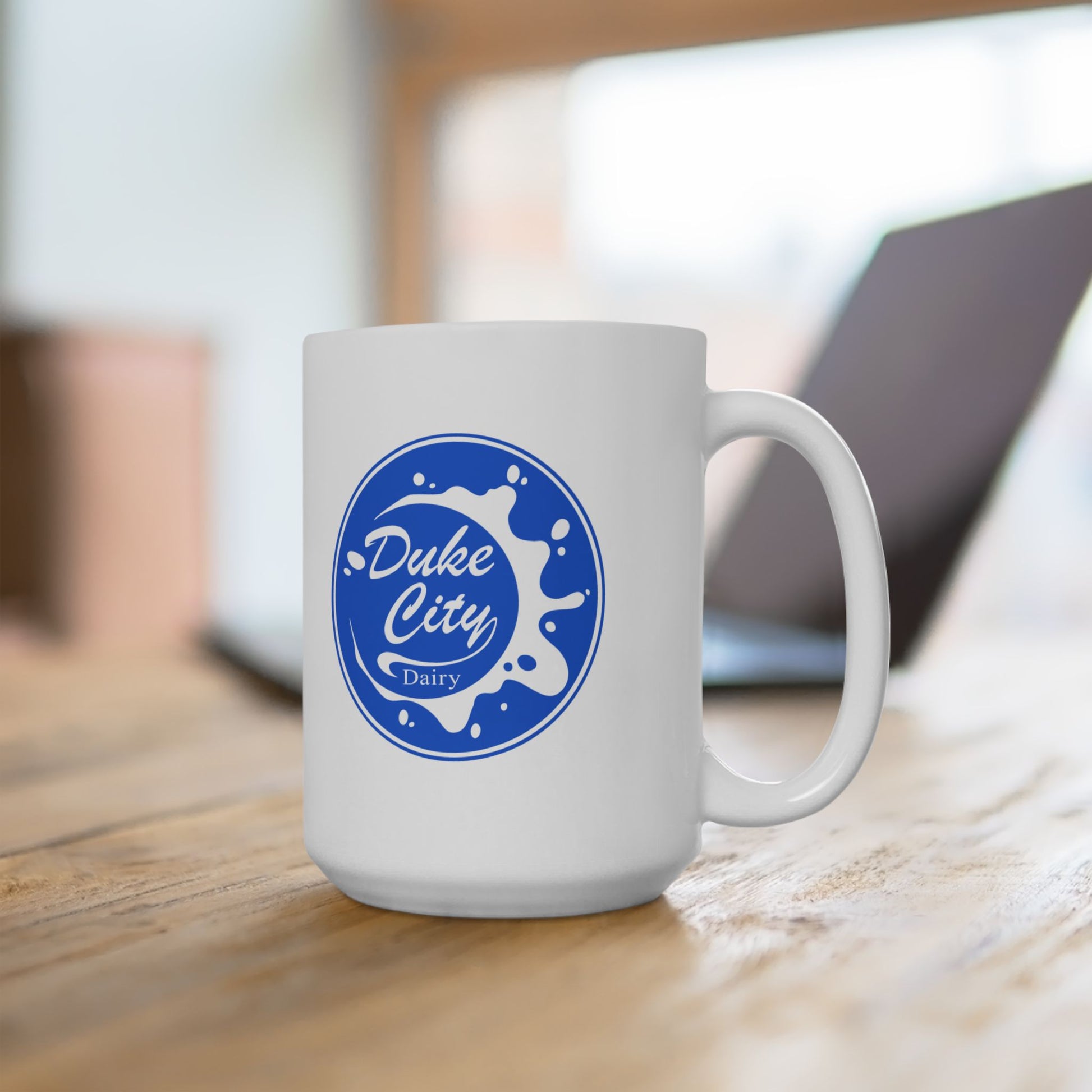 White mug with blue 'Duke City Dairy' logo from Pluribus on a wooden surface