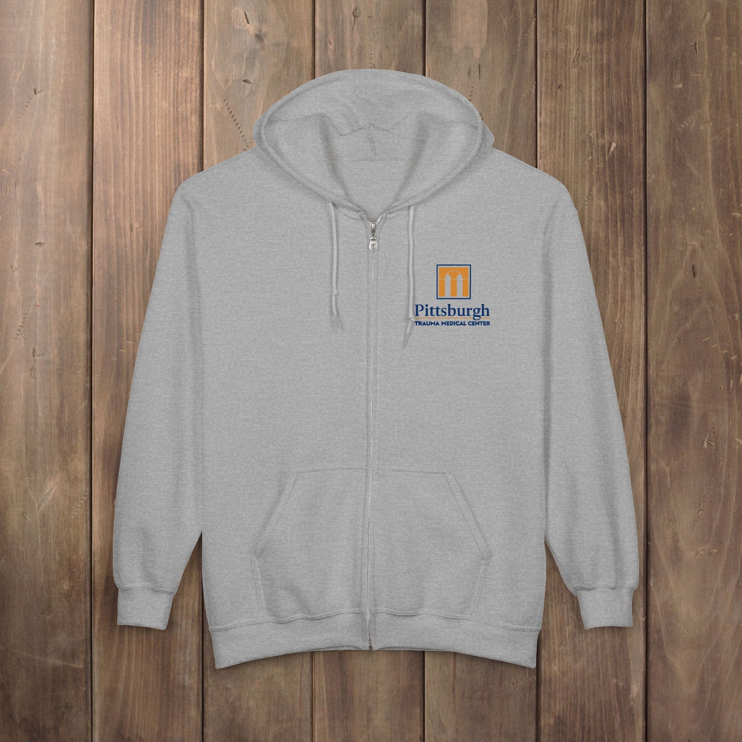 Sport Heather gray full-zip hoodie with the Pittsburgh Trauma Medical Center (PTMC) logo from The Pitt, printed on the left chest