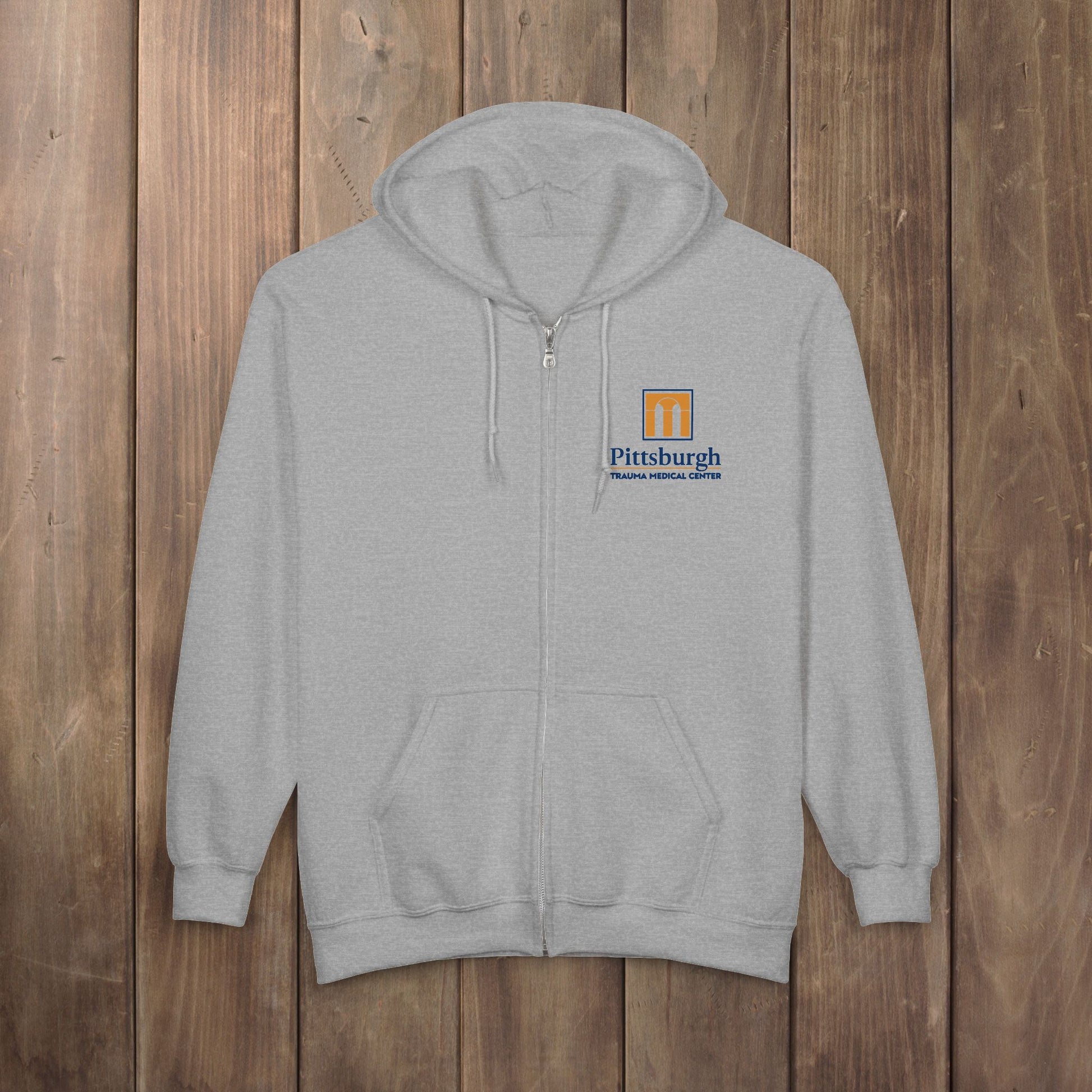 Sport Heather gray full-zip hoodie with the Pittsburgh Trauma Medical Center (PTMC) logo from The Pitt, printed on the left chest