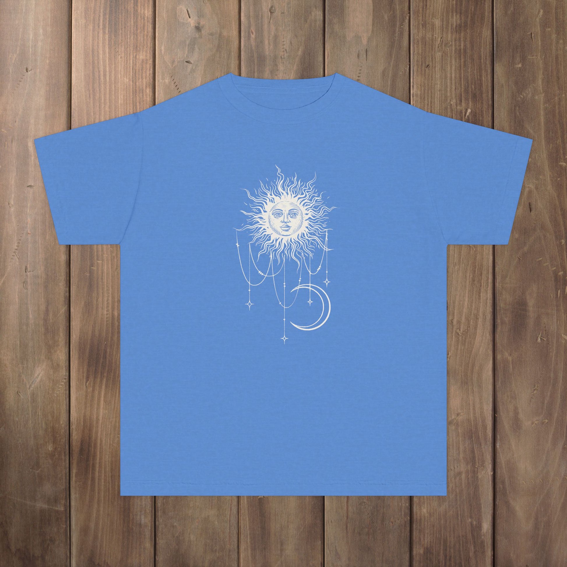 Front of royal caribe blue youth tee with Patricia boho celestial sun, stars, and crescent moon design from Widow's Bay