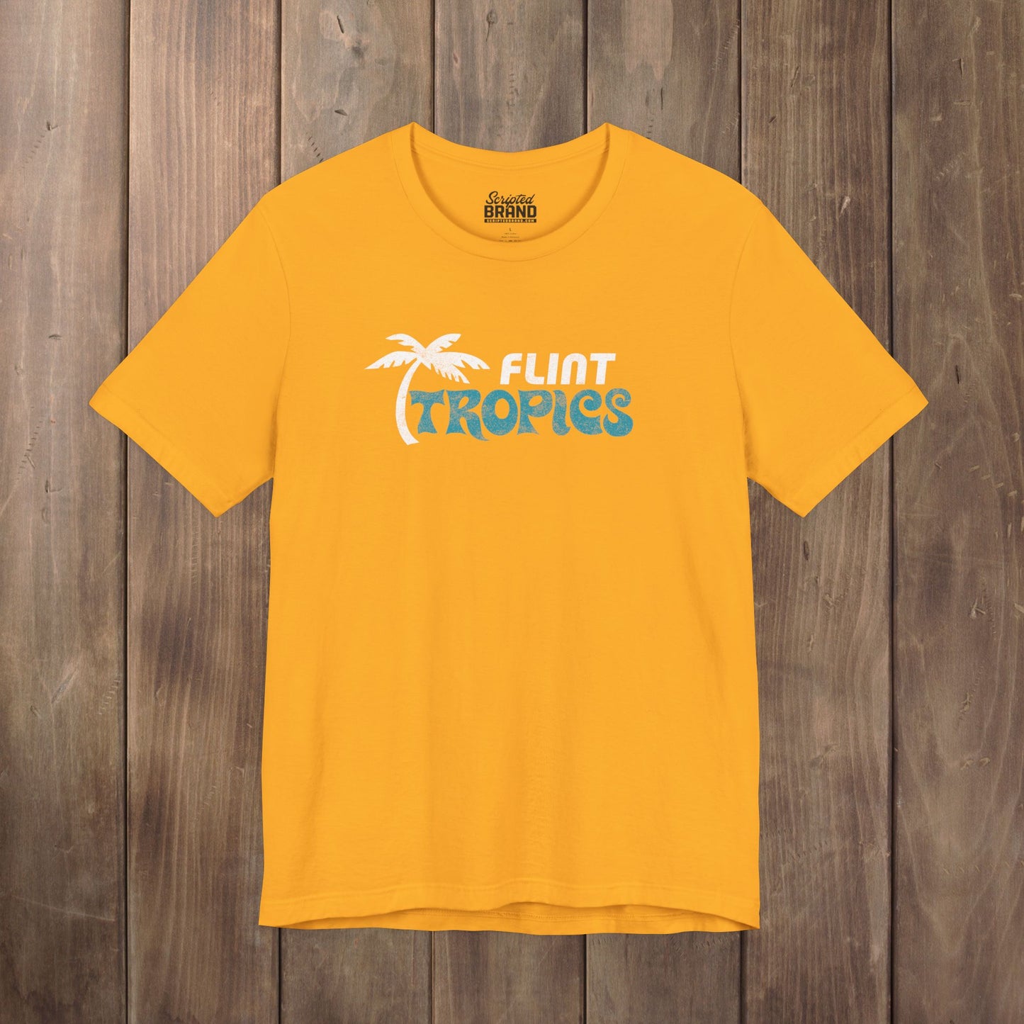 Gold Bella+Canvas t-shirt with the Flint Tropics logo from the movie Semi-Pro in a vintage distressed style.