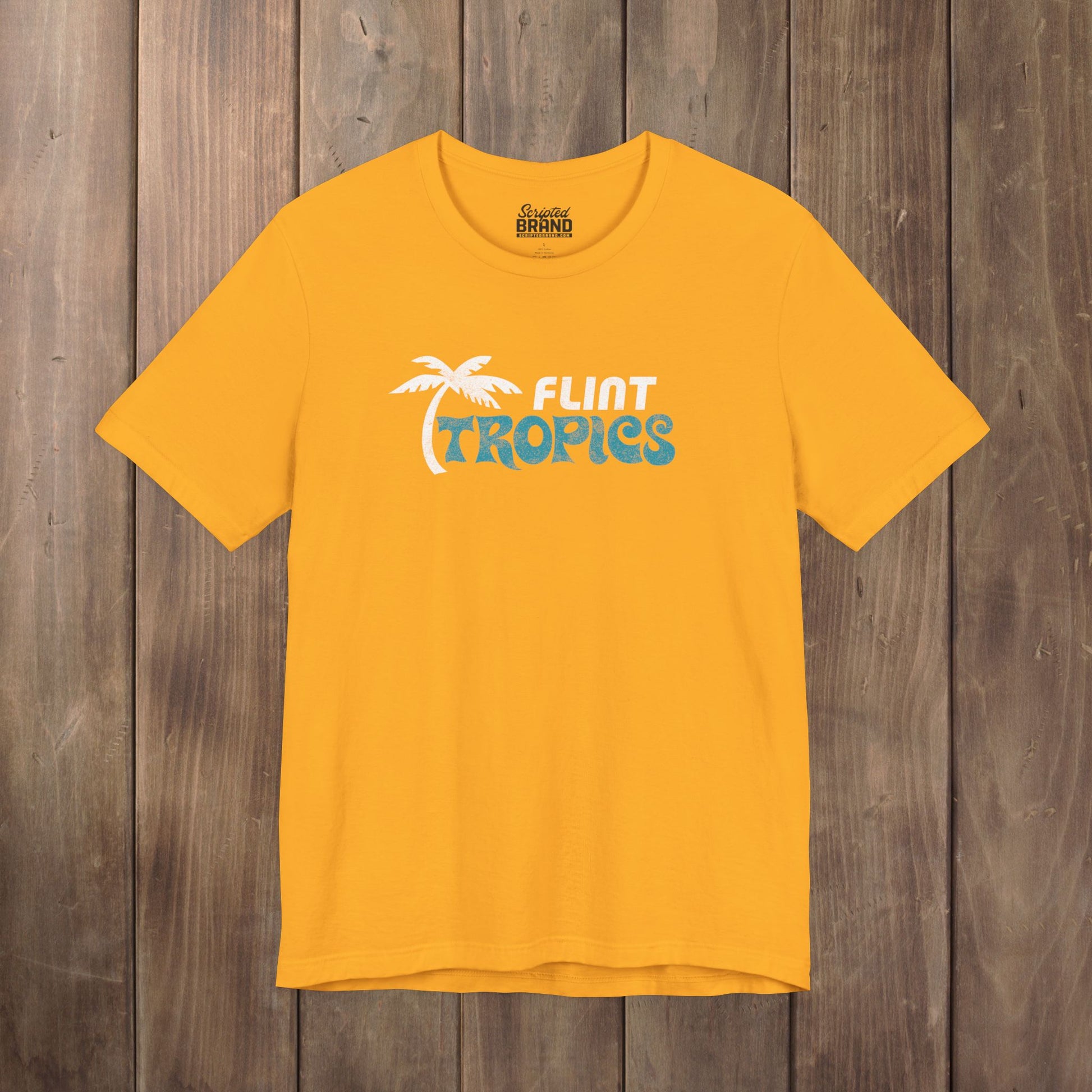 Gold Bella+Canvas t-shirt with the Flint Tropics logo from the movie Semi-Pro in a vintage distressed style.
