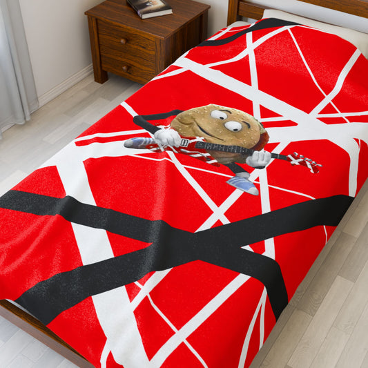 60x80 red, white, black Frankenstrat stripes plush blanket with singing hamburger guitar graphic, inspired by Better Off Dead and Van Halen, shown on bed.