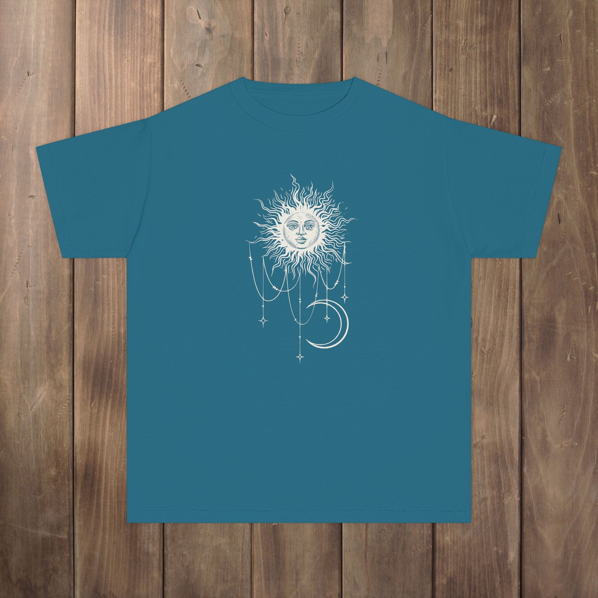 Front of topaz teal blue youth tee with Patricia boho celestial sun, stars, and crescent moon design from Widow's Bay