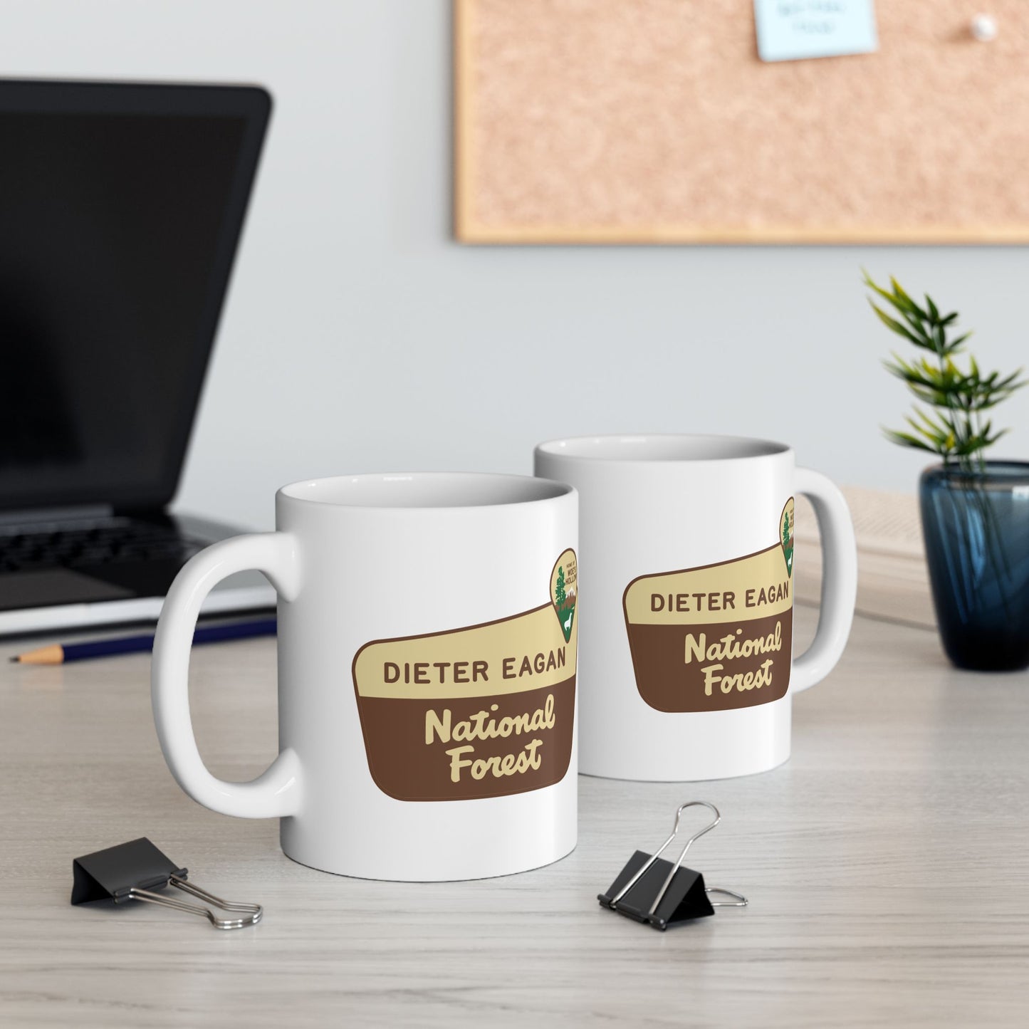 2 White ceramic mugs with Dieter Eagan National Forest logo, inspired by Woe’s Hollow episode in Severance.