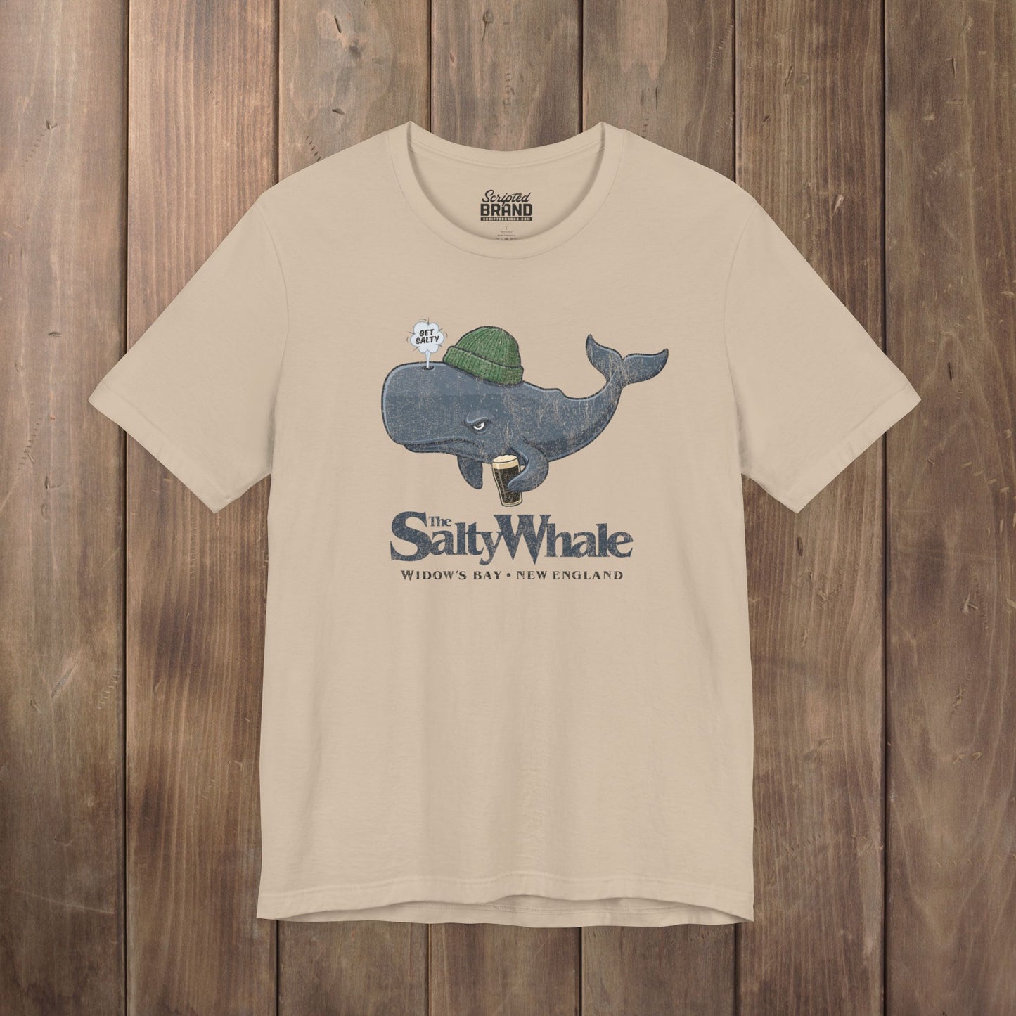 Tan cream 'The Salty Whale' cartoon mascot t-shirt inspired by Widow's Bay Apple TV series, soft Bella+Canvas cotton pub fan tee