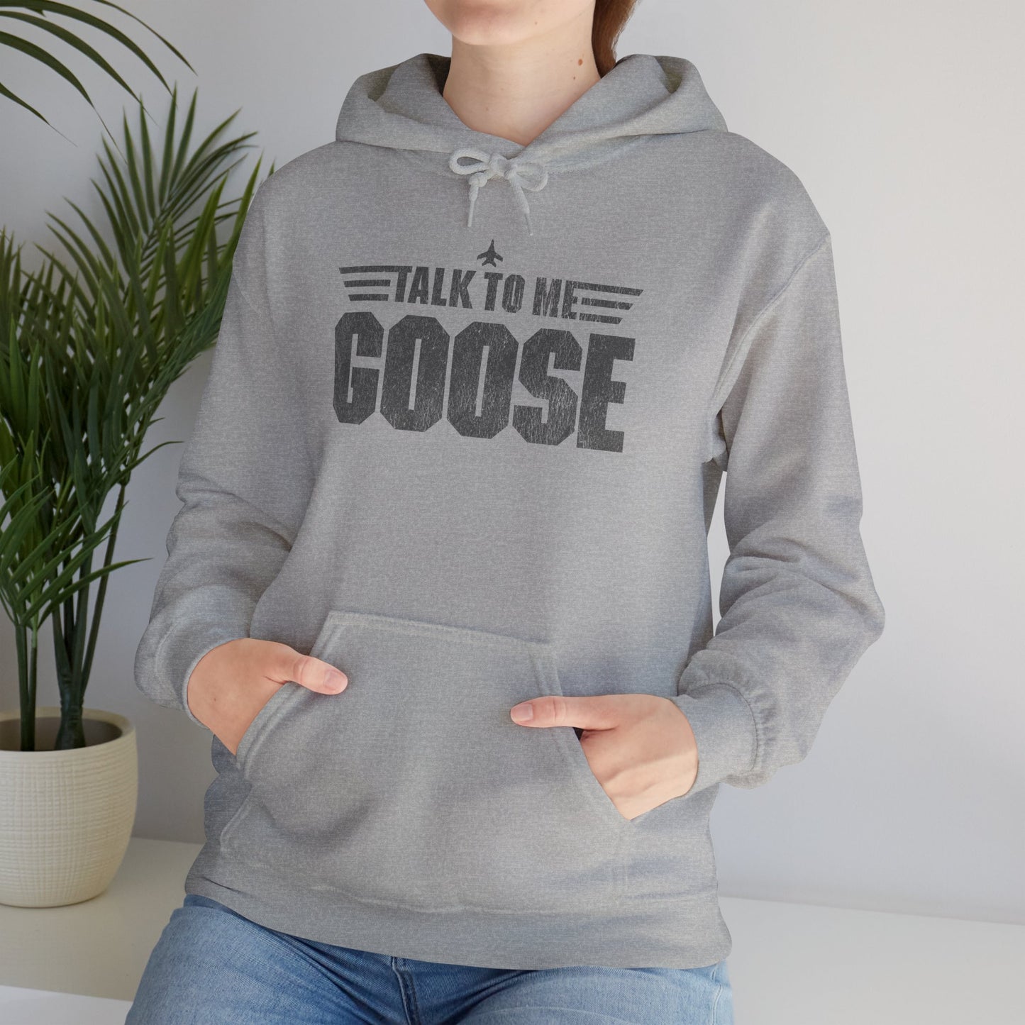 Woman wearing heather gray Talk to Me Goose vintage distressed graphic hoodie inspired by Top Gun, heavy blend cotton sweatshirt