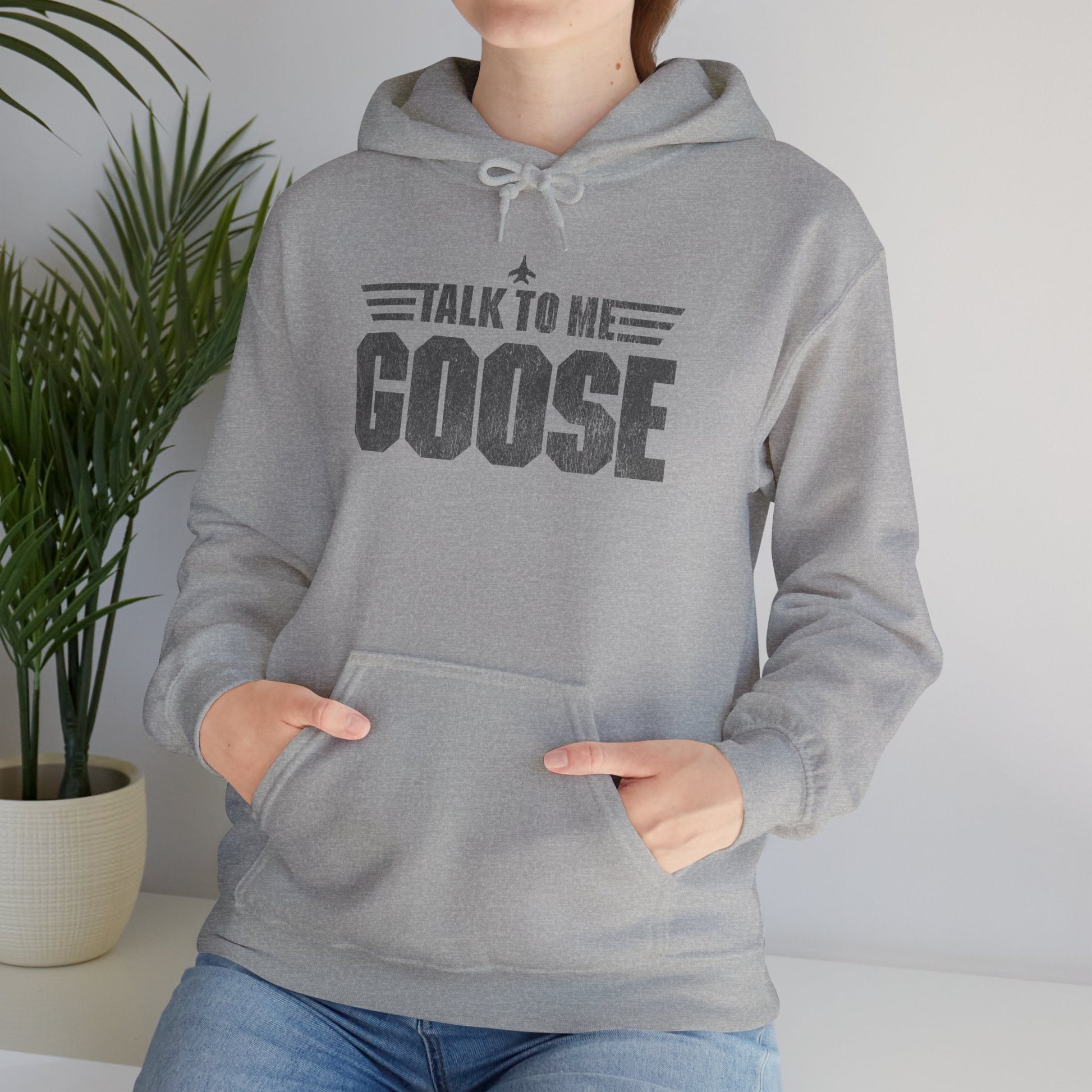 Woman wearing heather gray Talk to Me Goose vintage distressed graphic hoodie inspired by Top Gun, heavy blend cotton sweatshirt