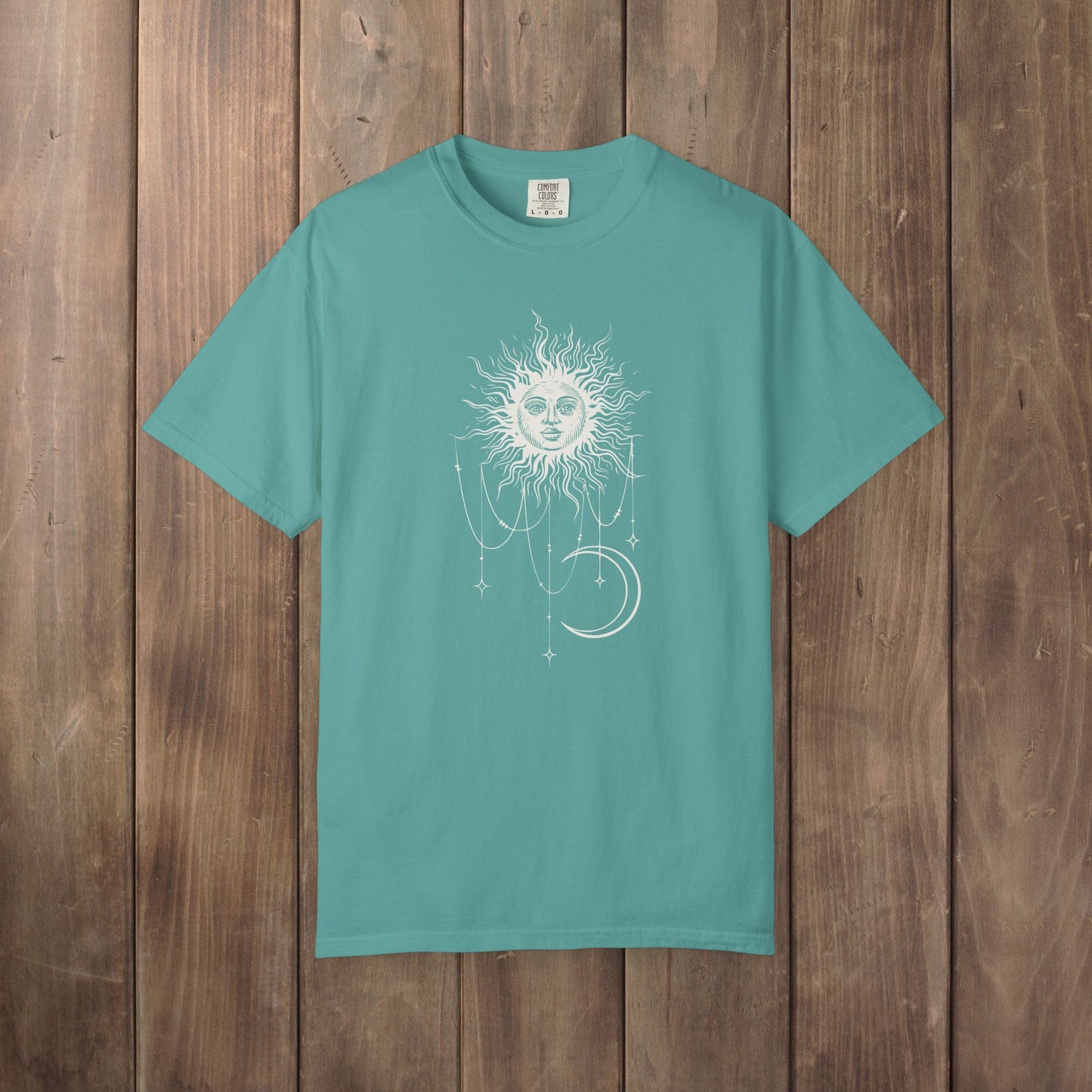 Seafoam green Comfort Colors tee with a celestial sun and crescent moon design, worn by Patricia in Widow's Bay S1E8