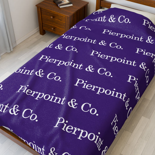 Velveteen Plush Blanket featuring a step and repeat pattern of Pierpoint & Co. logo from the HBO TV show Industry, placed on a small bed.