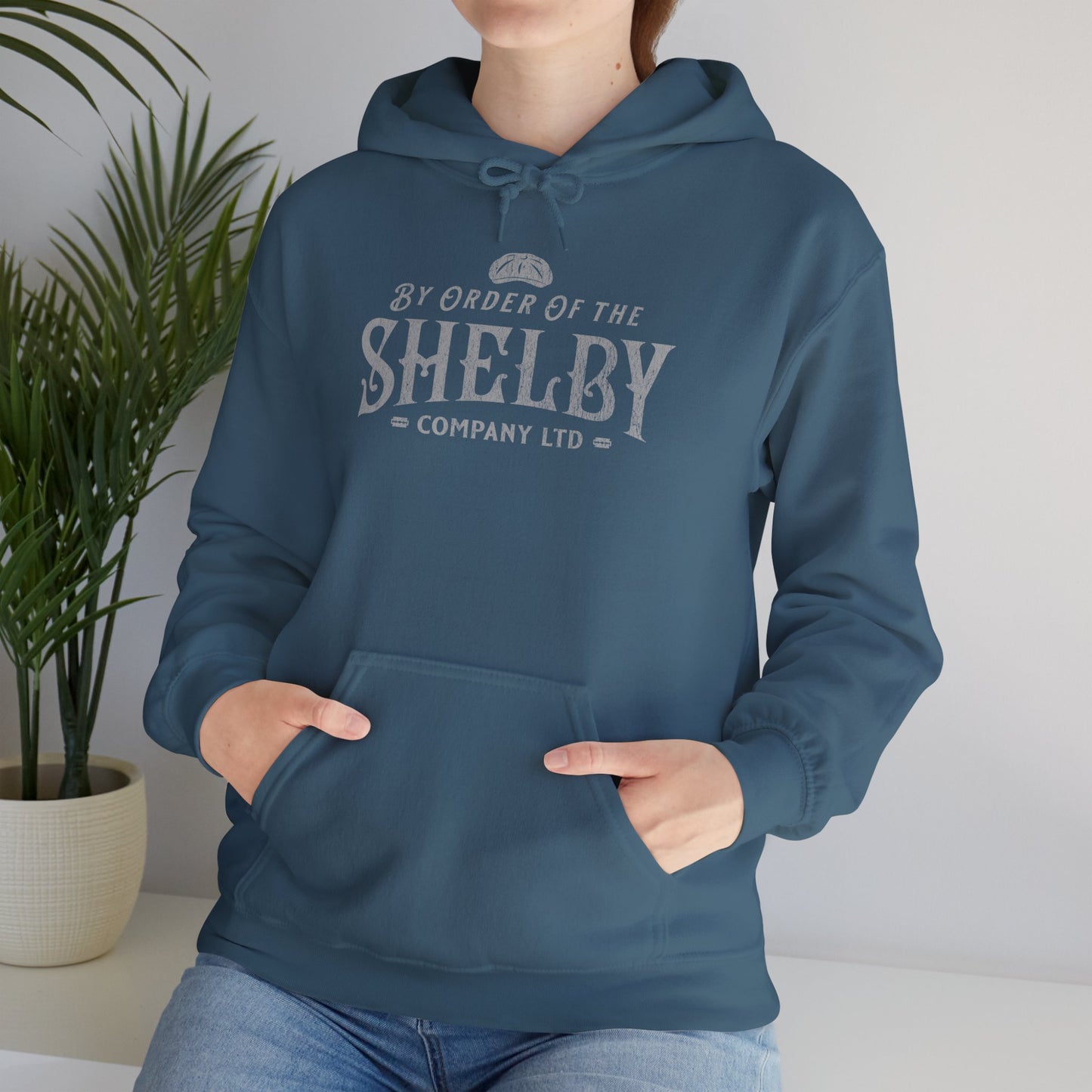Woman wearing indigo blue Unisex Gildan 18500 Heavy Blend Hoodie Sweatshirt with a vintage Shelby Company Limited logo graphic from Peaky Blinders.