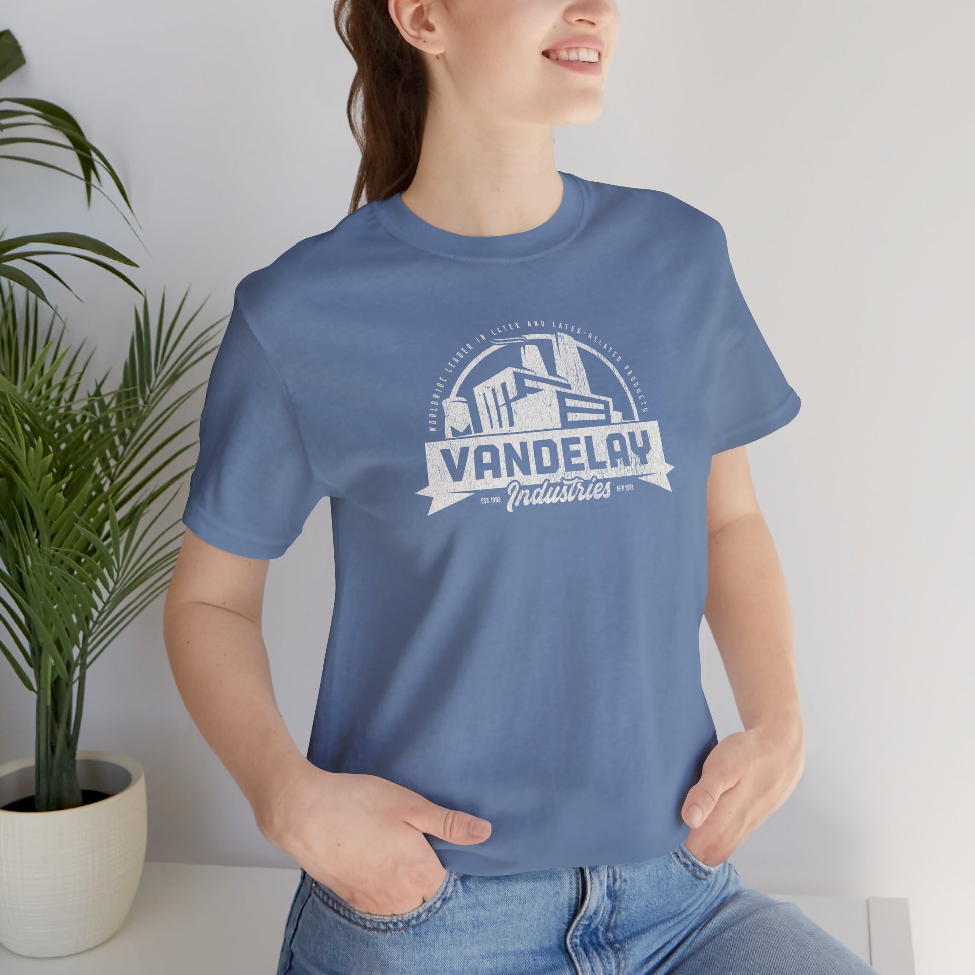 Person wearing Steel Blue Bella+Canvas 3001 t-shirt with a Vandelay Industries logo that George Costanza made up in the TV Show Seinfeld.