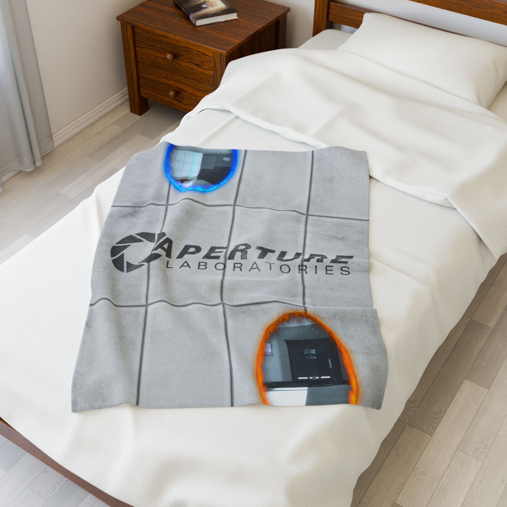 Angled view of 30x40 Velveteen plush blanket with Portal 2 panel wall, Aperture Laboratories logo, and blue and orange portals, shown on a bed.