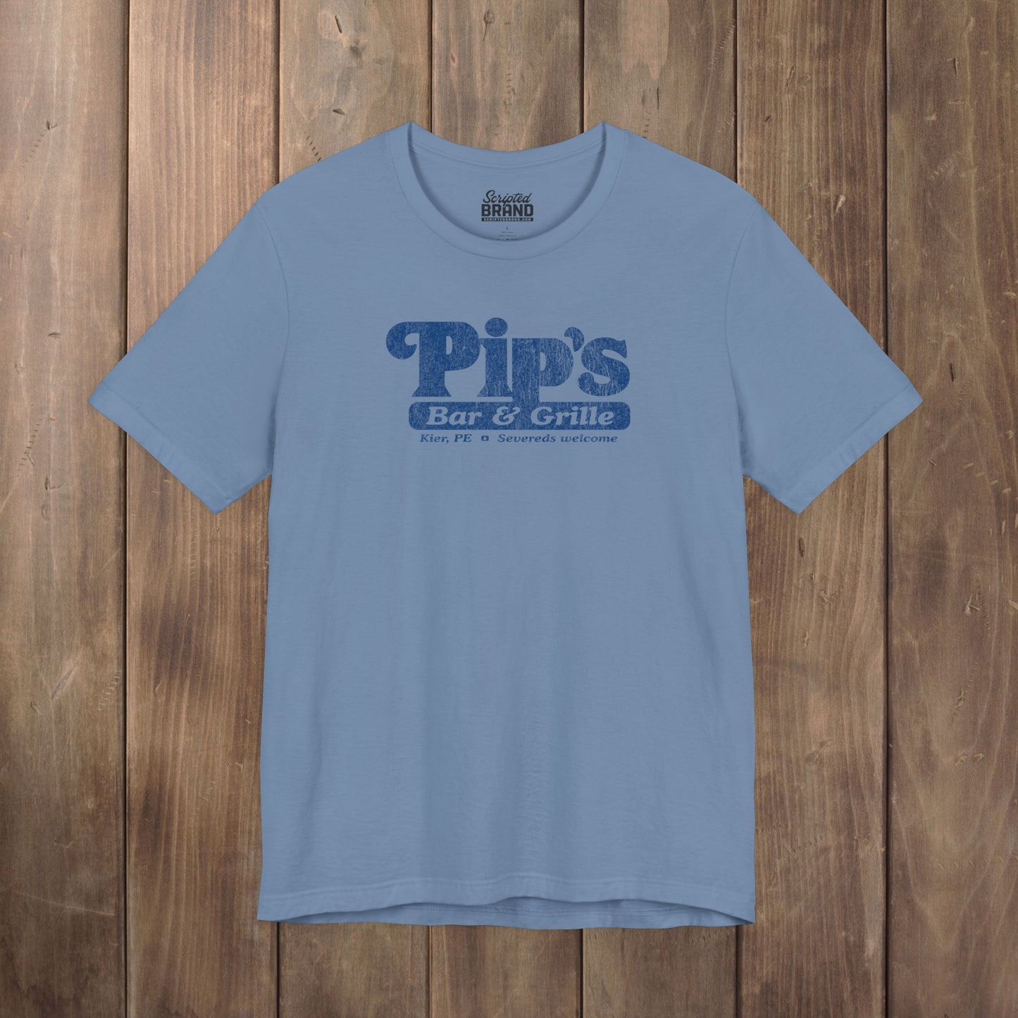Steel blue Bella+Canvas t-shirt with the Pips Bar and Grill logo from the TV show Severance in a vintage distressed style.