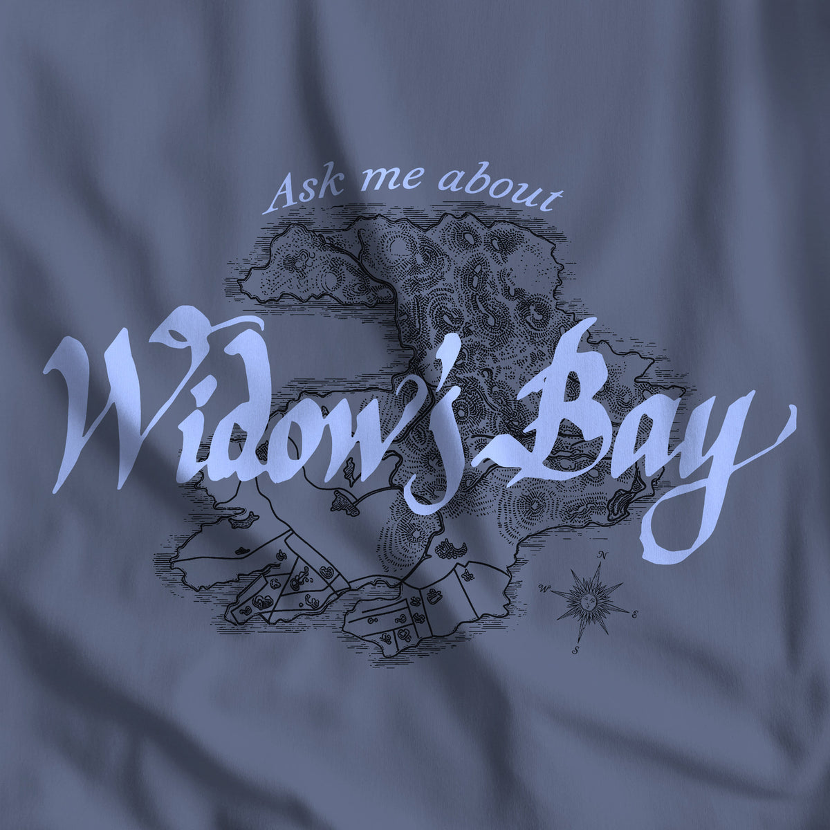 Closeup of Patricia Midnight blue Comfort Colors tee with a vintage island map and antique "Ask Me About Widow's Bay" type from the Apple TV show