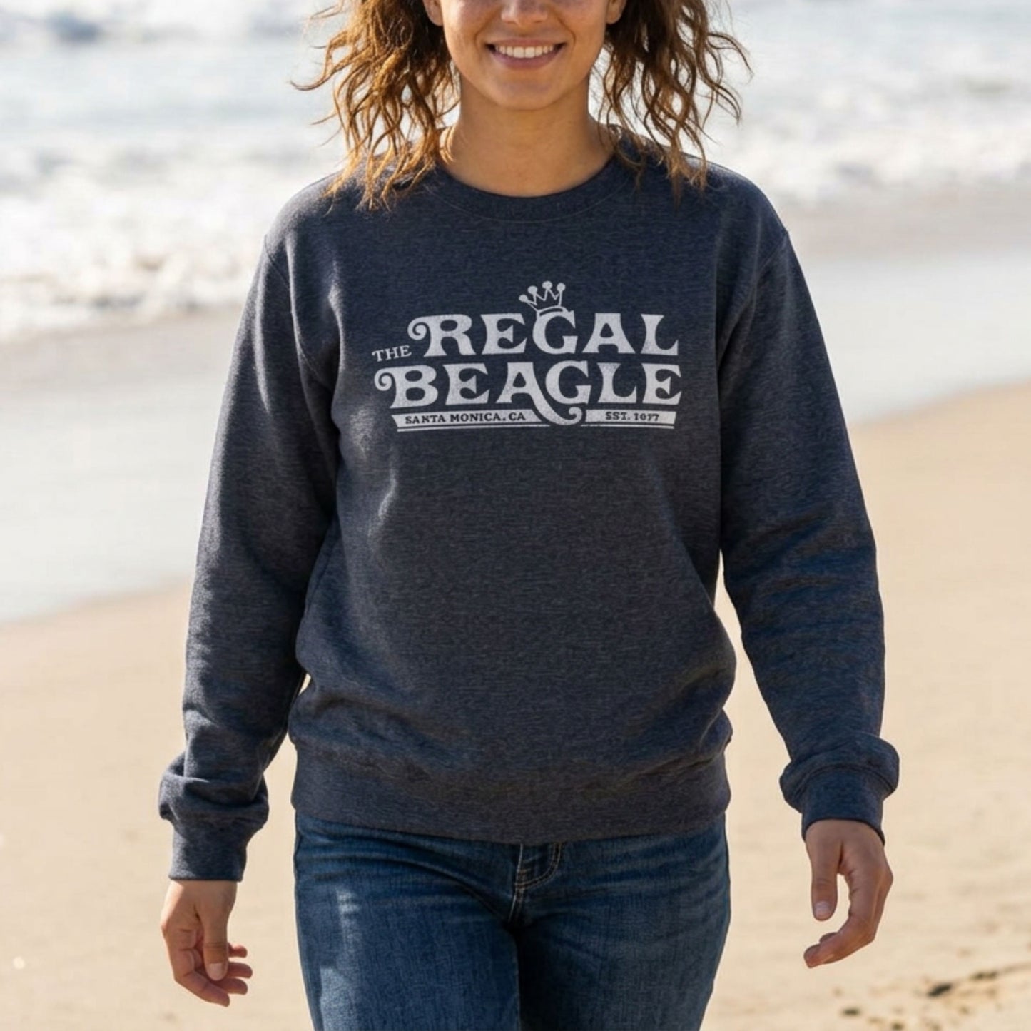Woman wearing heather navy blue crewneck sweatshirt with vintage distressed blue Regal Beagle Three's Company logo