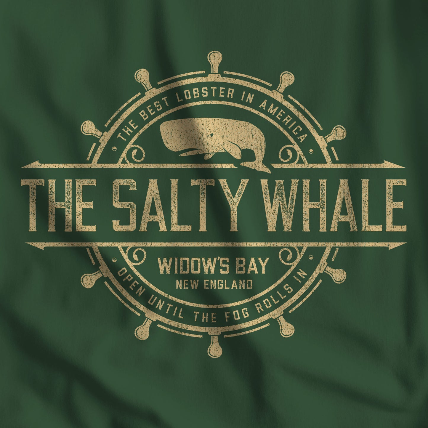 Closeup of Forest green Gildan crewneck sweatshirt with the distressed Salty Whale maritime crest logo from TV show Widow's Bay
