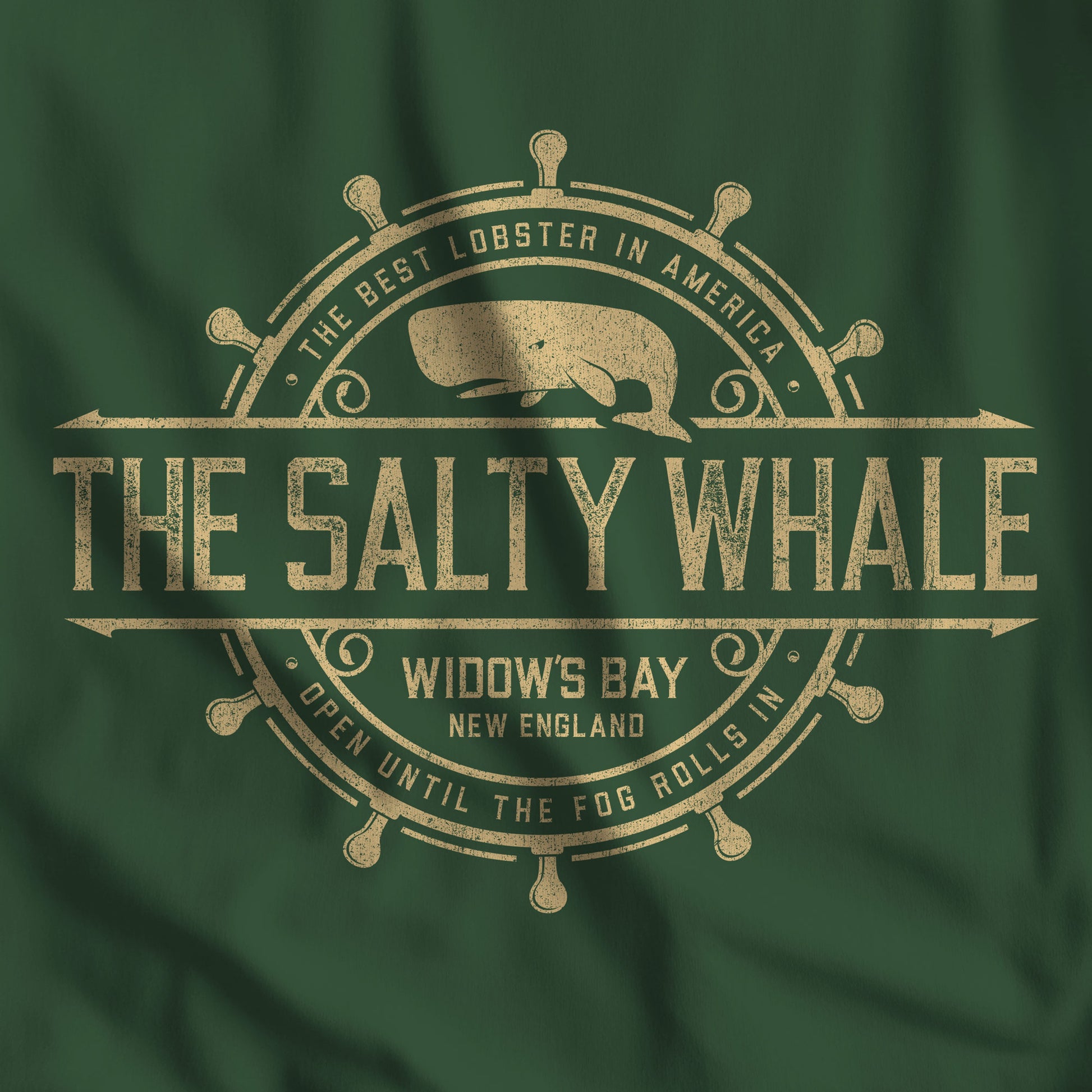 Closeup of Forest green Gildan crewneck sweatshirt with the distressed Salty Whale maritime crest logo from TV show Widow's Bay