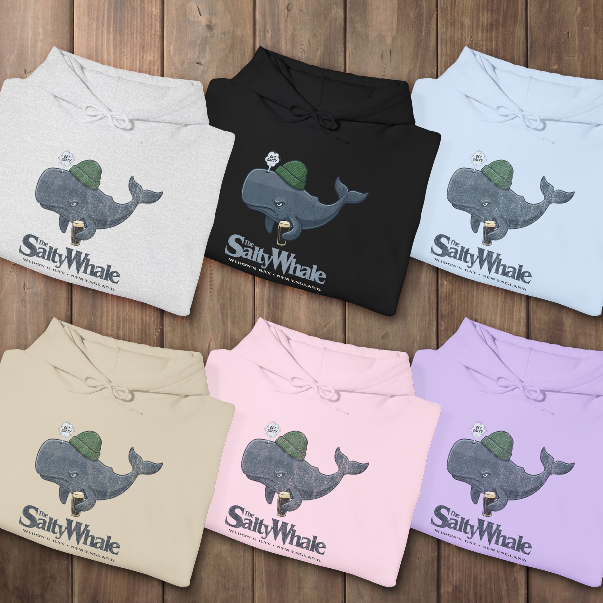 Six folded 'The Salty Whale' cartoon mascot hoodies inspired by Widow's Bay Apple TV series, heavy blend pullover sweatshirt