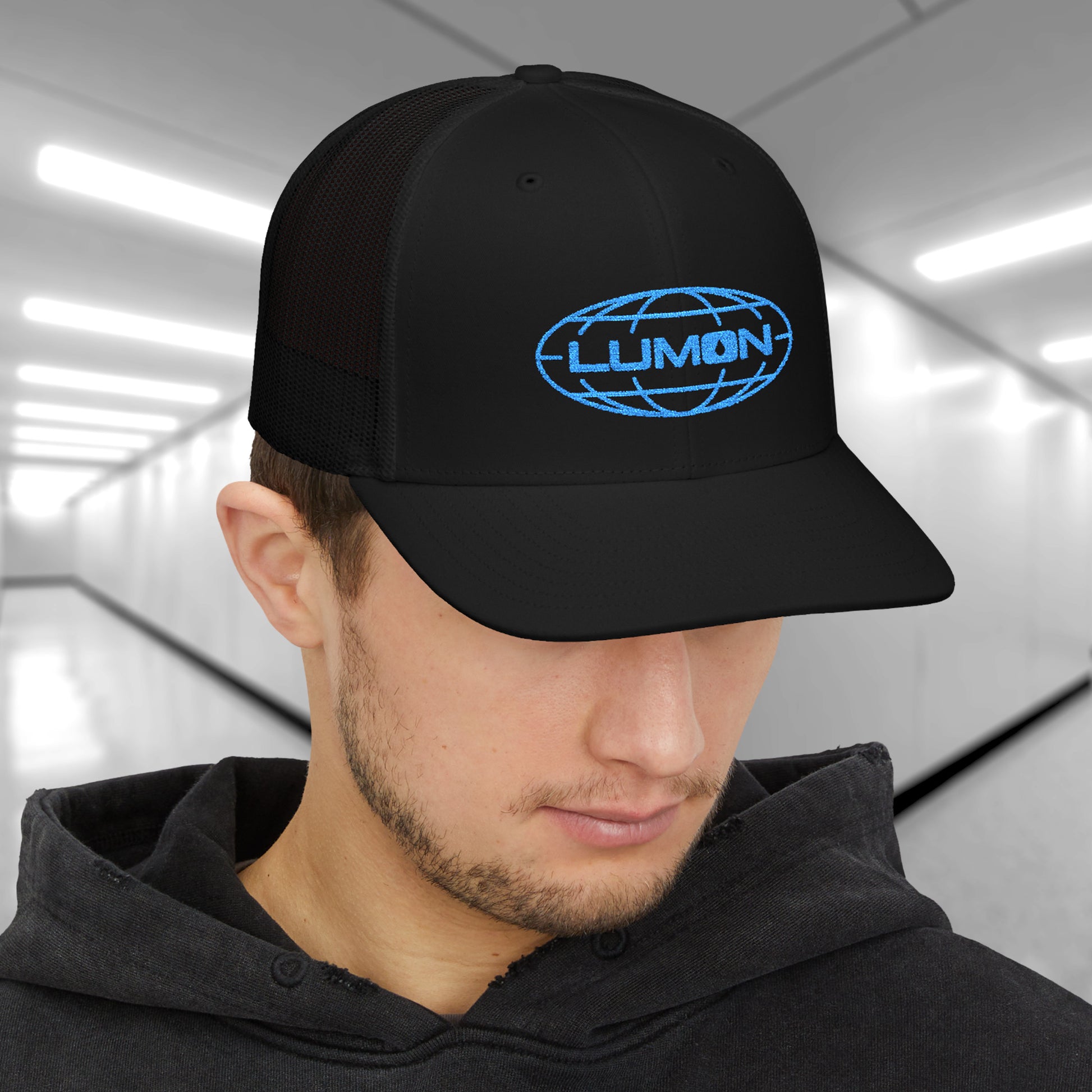 Man wearing black Richardson 112 trucker cap with embroidered blue Lumon Industries logo inspired by TV show Severance.