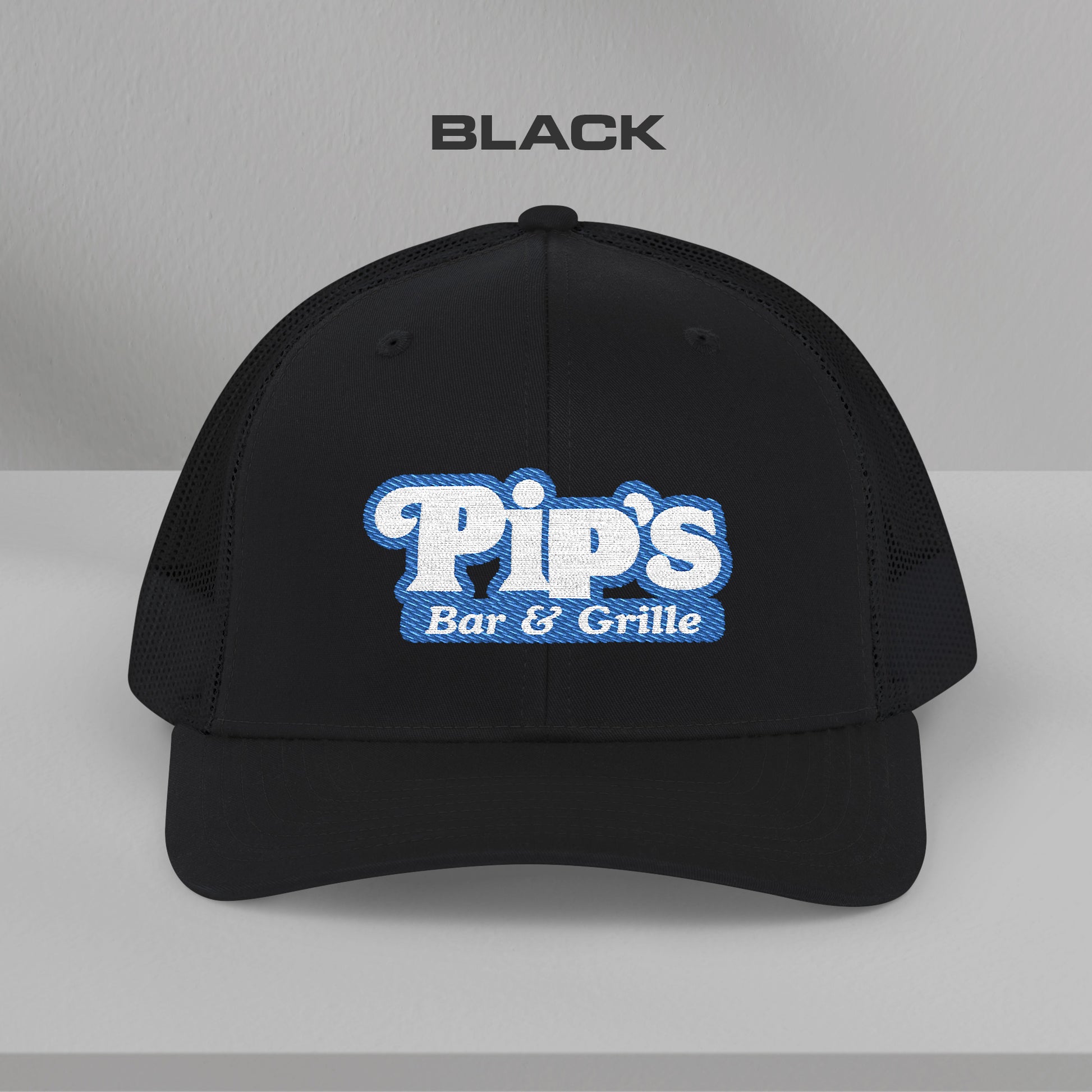 Front view of black Richardson 112 trucker hat with embroidered Pip’s Bar & Grille logo inspired by Severance.