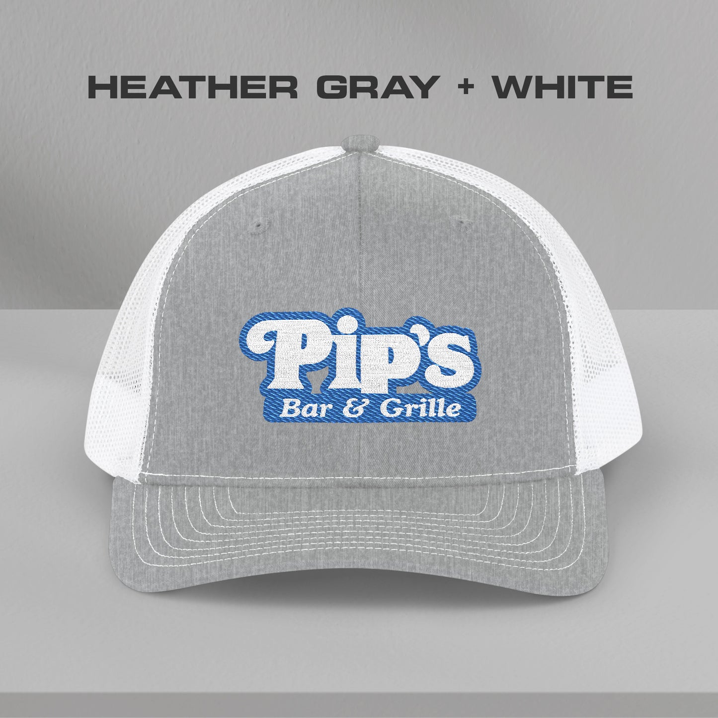 Front view of gray and white Richardson 112 trucker hat with embroidered Pip’s Bar & Grille logo inspired by Severance.