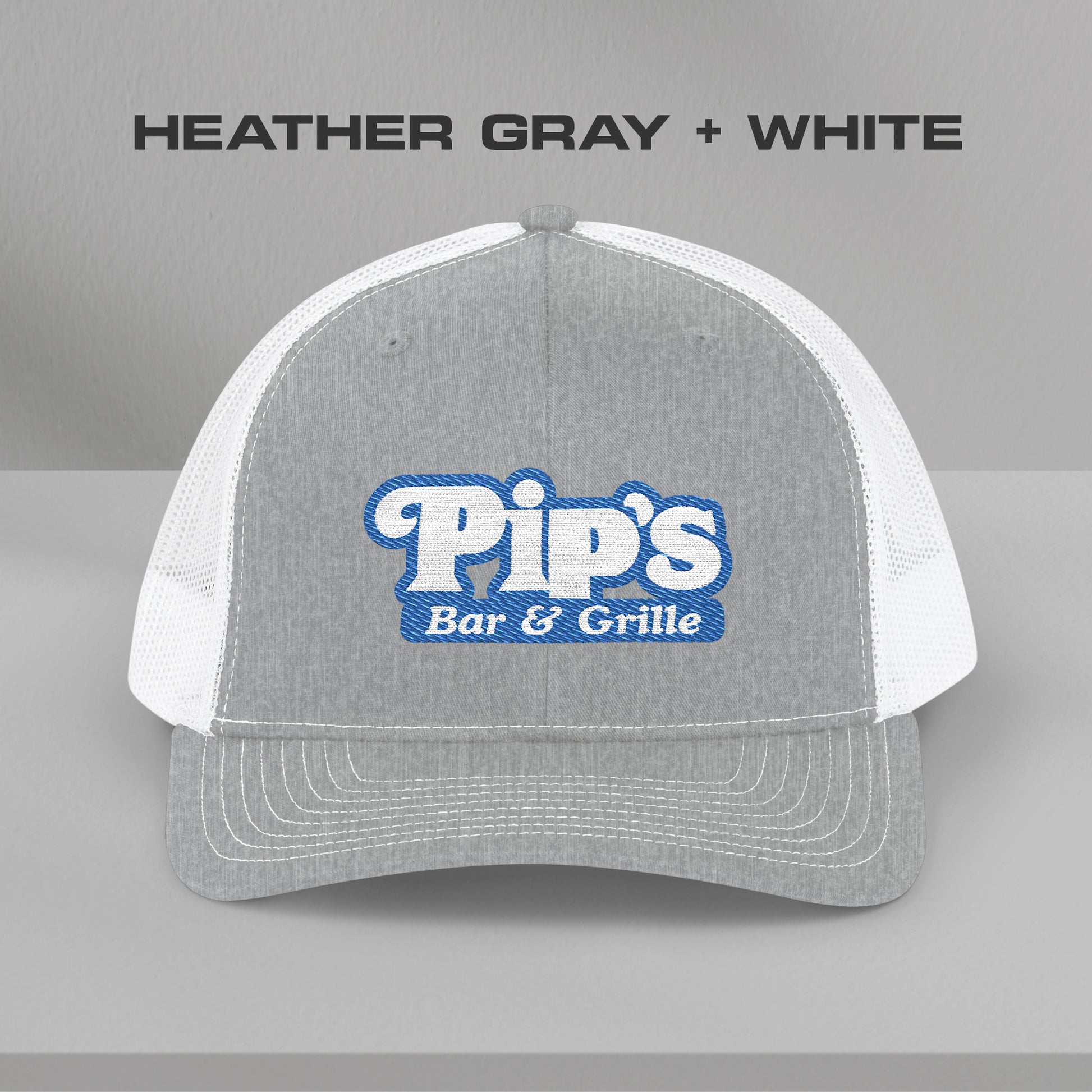 Front view of gray and white Richardson 112 trucker hat with embroidered Pip’s Bar & Grille logo inspired by Severance.