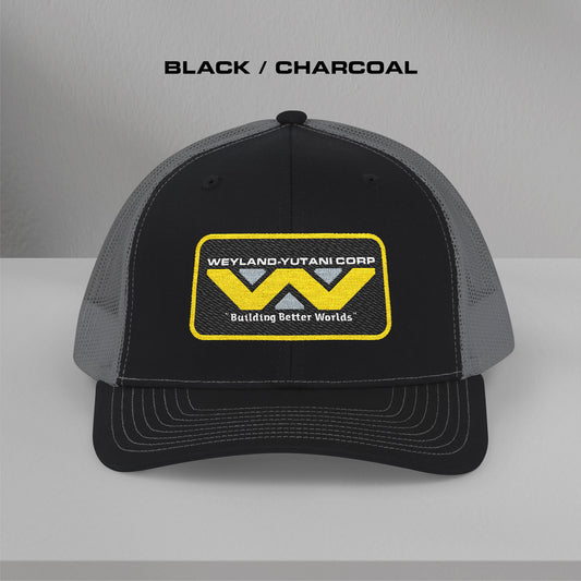 Front view of black-charcoal Embroidered Snapback Trucker Cap with logo of Weyland-Yutani from the Alien movie franchise.