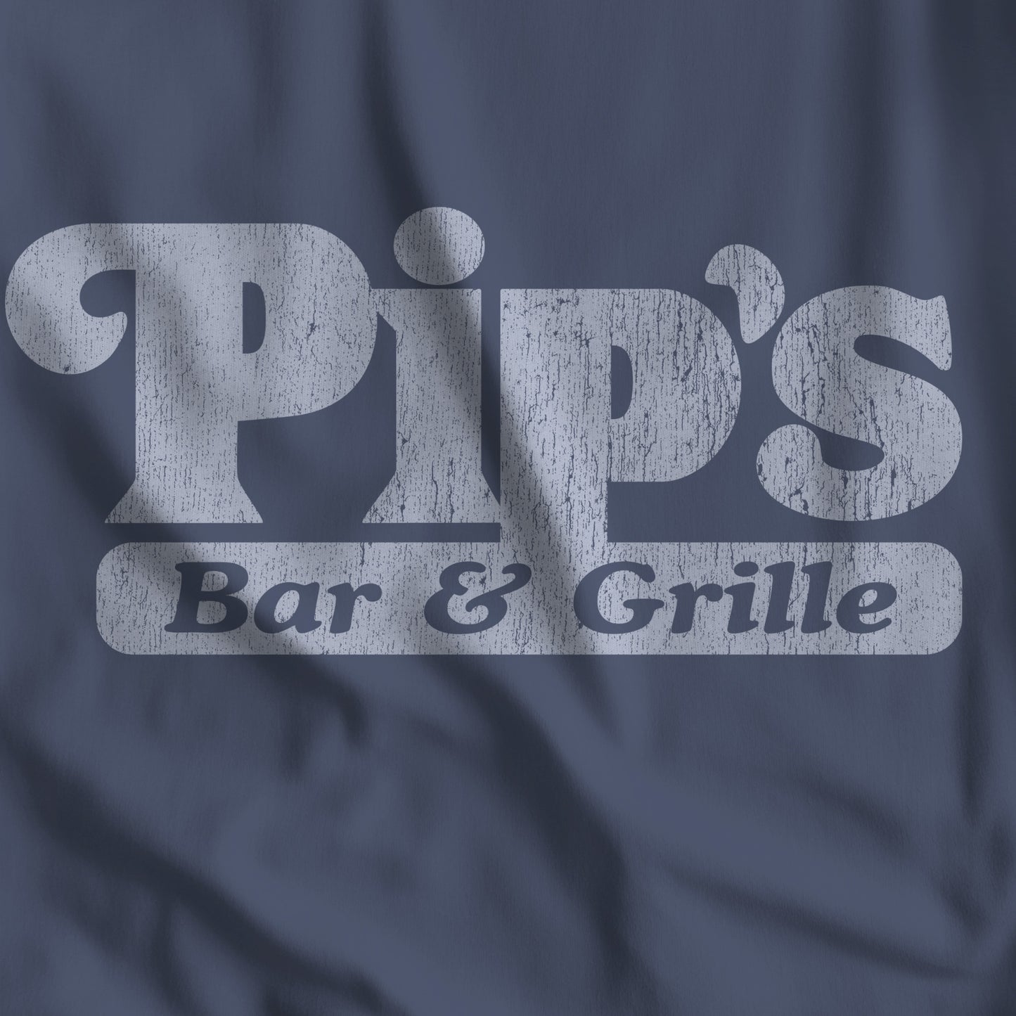 Closeup of midnight blue vintage-style Pip’s Bar and Grill t-shirt from TV show Severance on Comfort Colors 1717 tee.