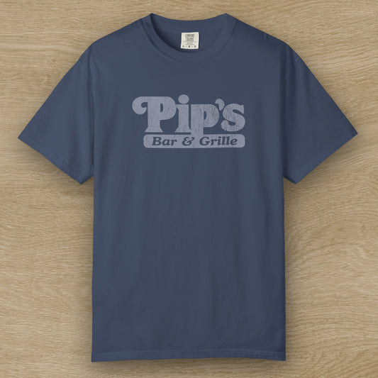 Vintage-style Pip’s Bar & Grill t-shirt from Severance on Comfort Colors 1717 in the color midnight, distressed logo.