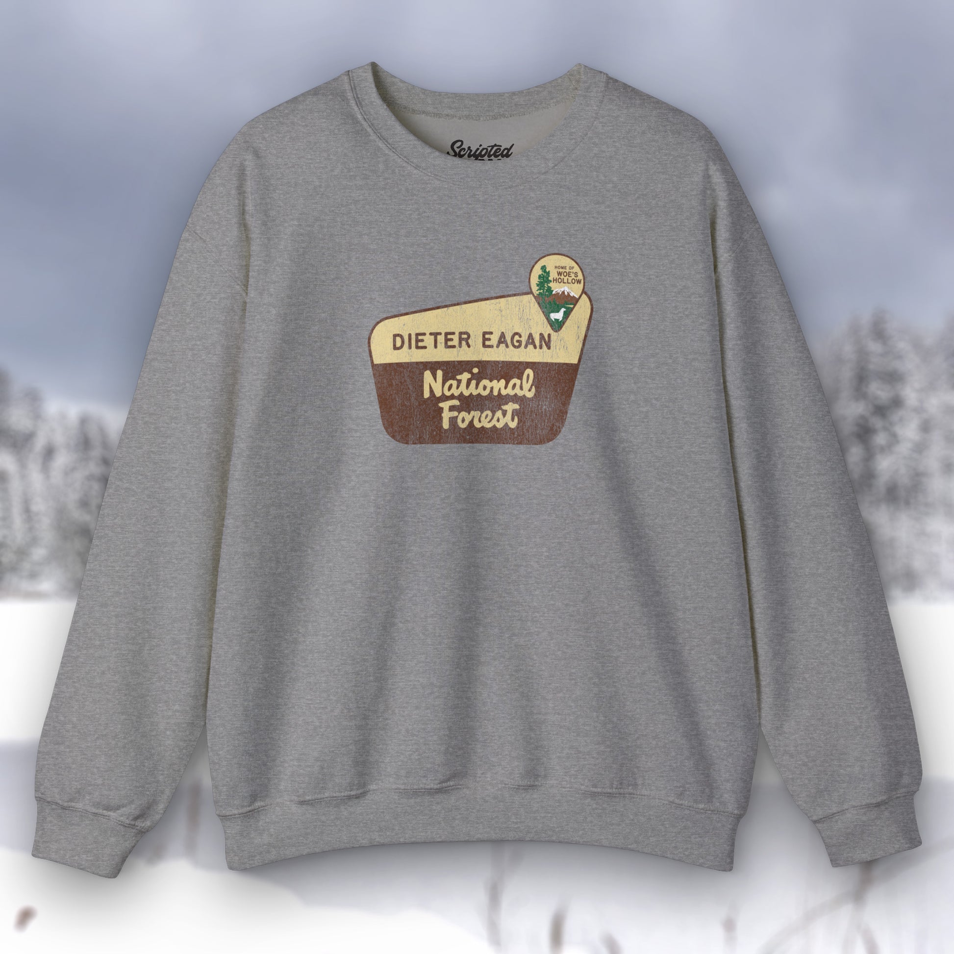Front view of a dark gray heather Soft Unisex Gildan 18000 sweatshirt featuring a logo graphic of the Dieter Eagan National Forest sign designed by ScriptedBrand, inspired by the TV show Severance in a vintage distressed style.