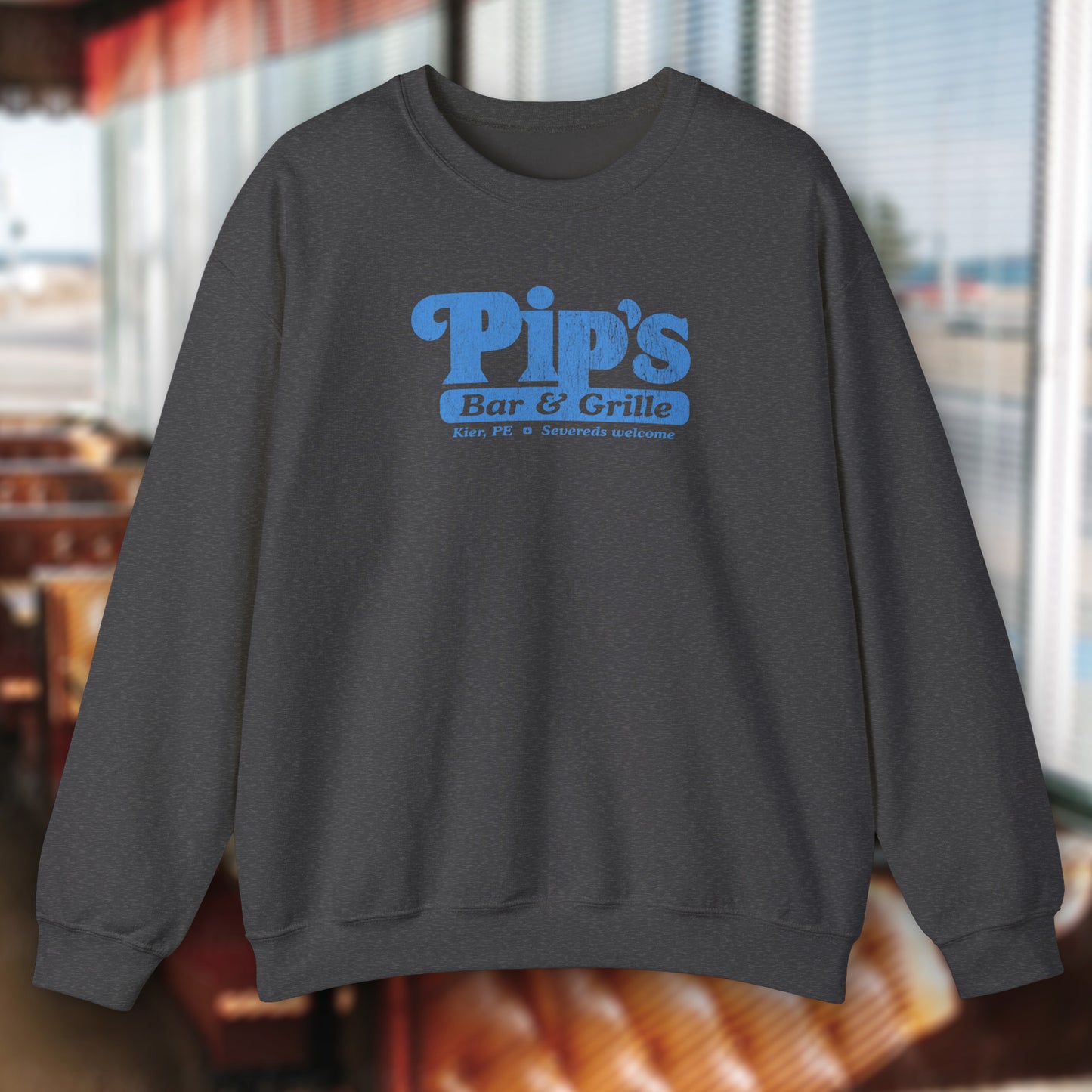 Dark heather gray soft Gildan 18000 sweatshirt featuring the Pips Bar and Grill logo Severeds Welcome from the TV show Severance in a vintage distressed ink-stamped worn-in style.