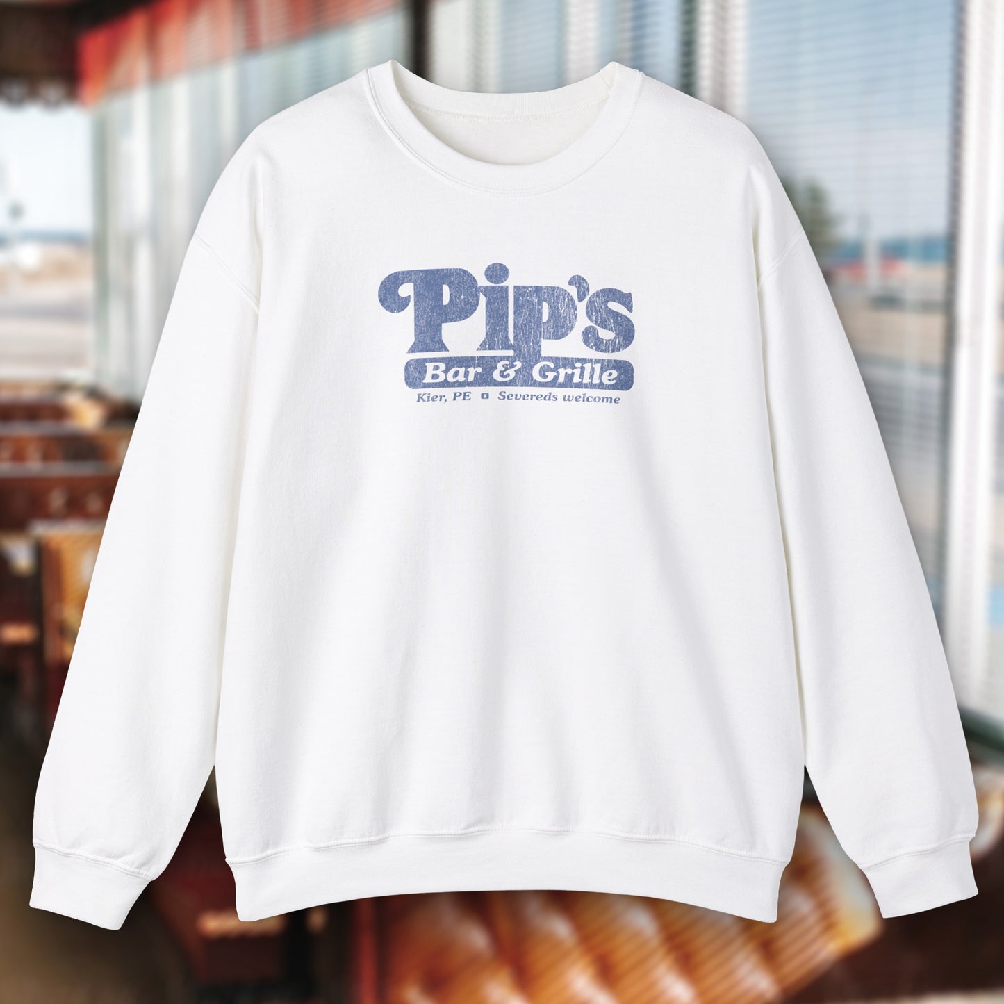 White soft Gildan 18000 sweatshirt featuring the Pips Bar and Grill logo Severeds Welcome from the TV show Severance in a vintage distressed ink-stamped worn-in style.