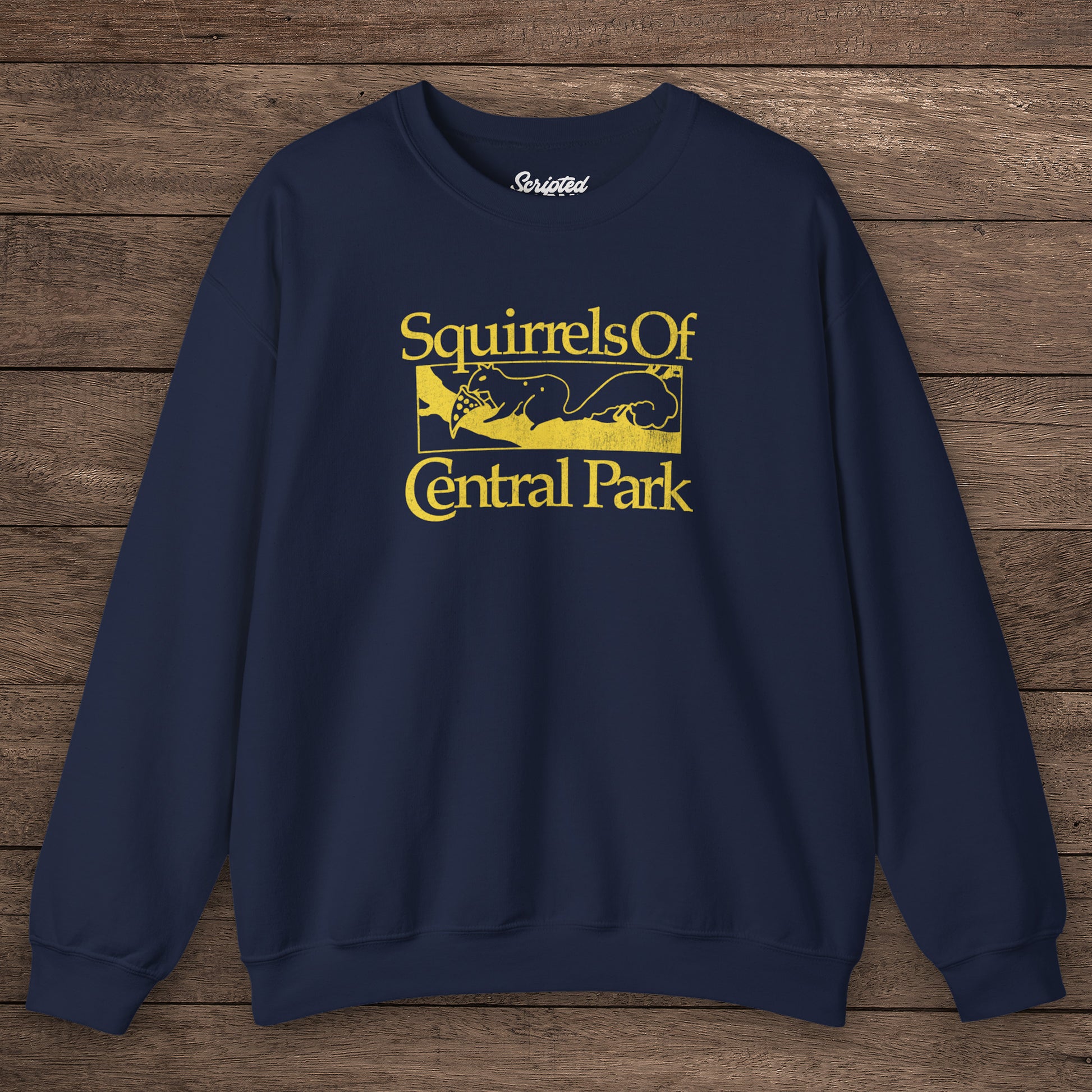 Navy blue Squirrels Of Central Park vintage distressed crewneck sweatshirt inspired by Bad Sisters, shown on wooden background.