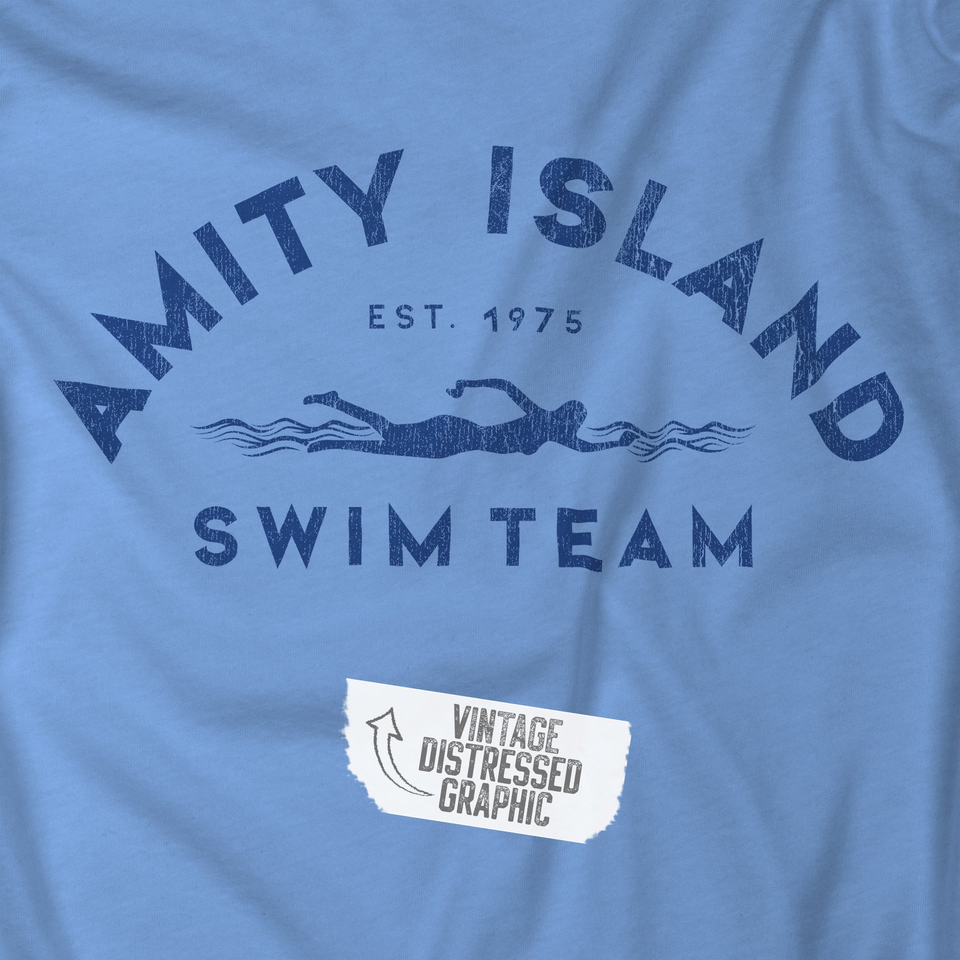 Closeup view of a Carolina Blue colored Soft Unisex Hoodie Heavy Blend Hooded Sweatshirt featuring an Amity Island Swim Team logo graphic, designed by ScriptedBrand, and  inspired by the movie Jaws in a vintage distressed style.