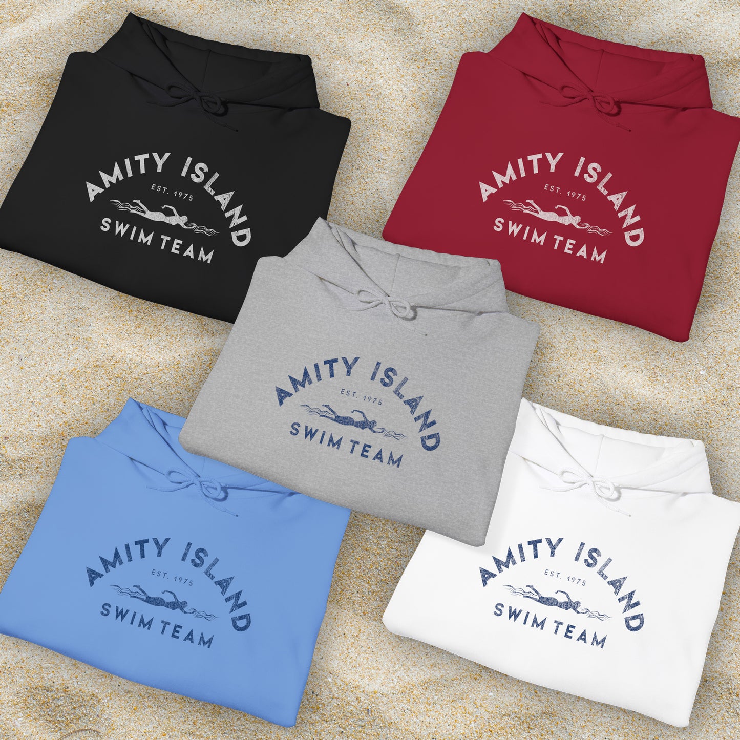 Group of 5 folded Soft Unisex Hoodie Heavy Blend Hooded Sweatshirts featuring an Amity Island Swim Team logo graphic, designed by ScriptedBrand, and  inspired by the movie Jaws in a vintage distressed style.