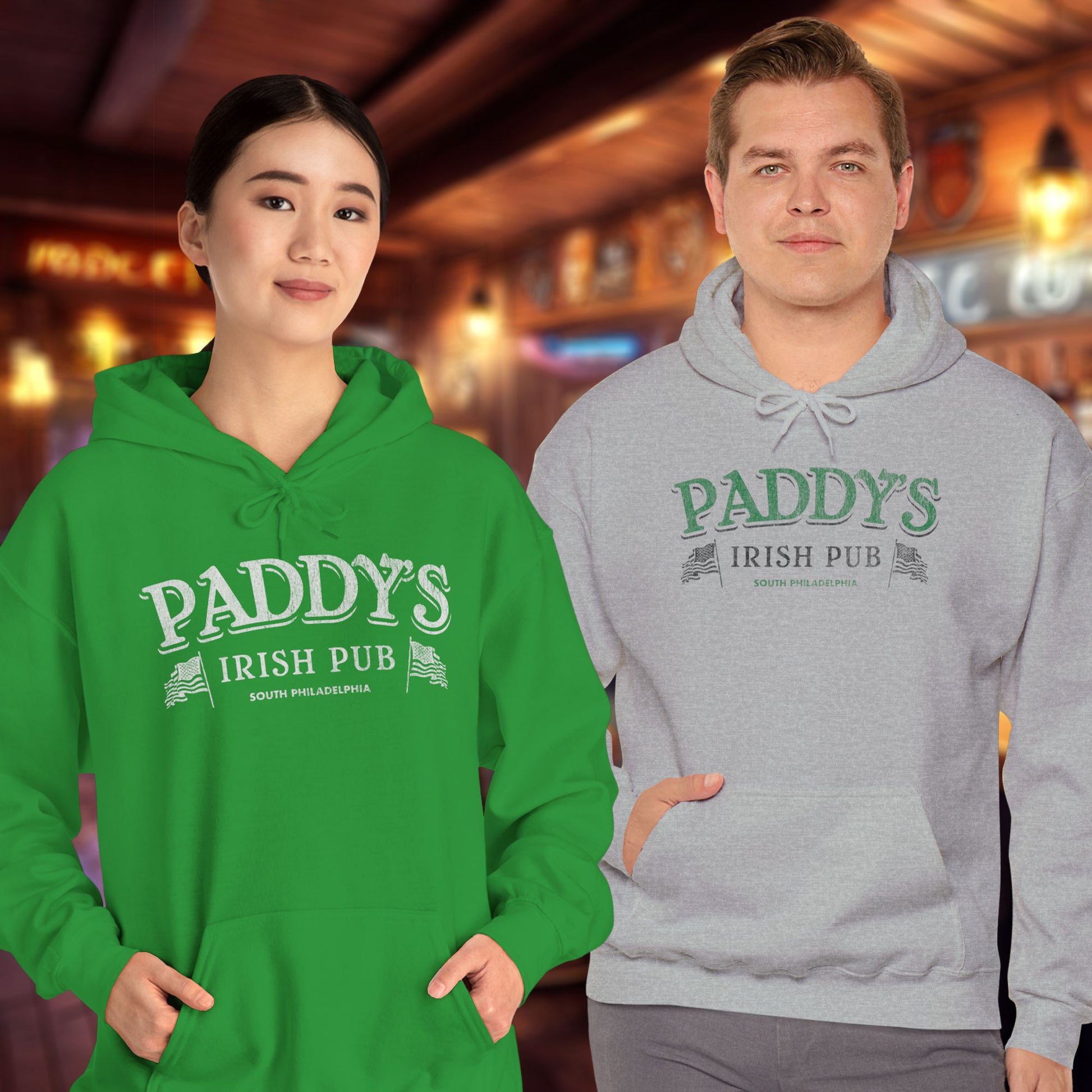 Two people wearing Hoodie Sweatshirts with the Paddy's Pub logo graphic from the TV Show Its Always Sunny in Philadelphia in a vintage style.