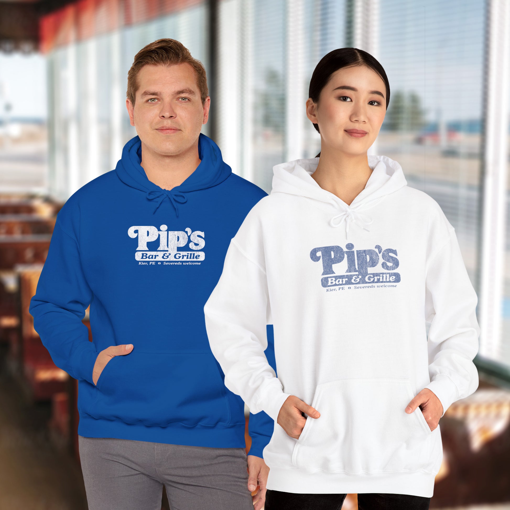 2 models wearing Soft Unisex Hoodie Heavy Blend Hooded Sweatshirts featuring the Pips Bar & Grill logo, with the added text "Severeds Welcome" inspired by the TV show Severance in a vintage distressed style, sold by ScriptedBrand.