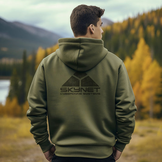 Person wearing a military green hoodie Sweatshirt featuring the fictional logo Skynet Cyberdyne Systems from the movie The Terminator printed on both sides in a vintage distressed style.