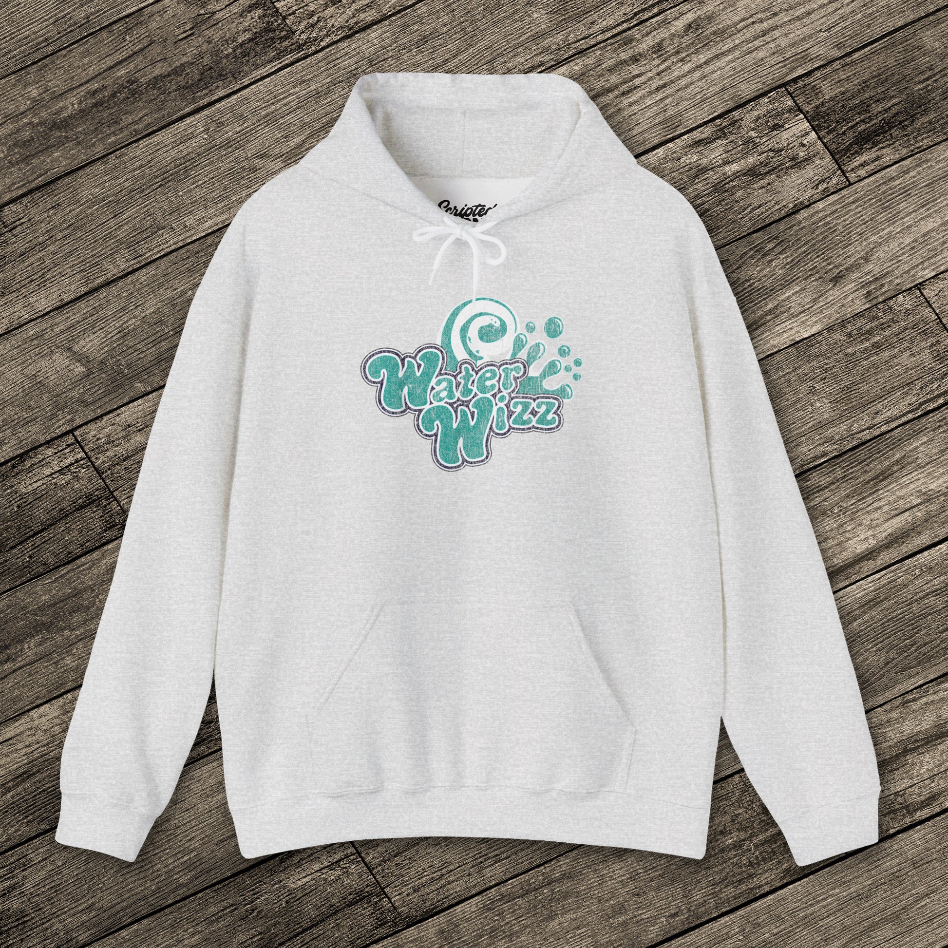 Ash gray Gildan 18500 pullover hoodie with vintage distressed Water Wizz logo from Grown Ups on the chest, shown on wood floor.