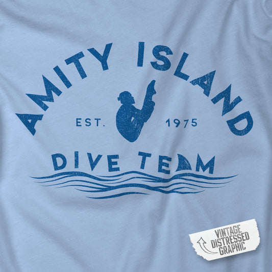 Closeup of baby blue Bella+Canvas t-shirt with vintage-style Amity Island Dive Team logo, inspired by the movie Jaws.