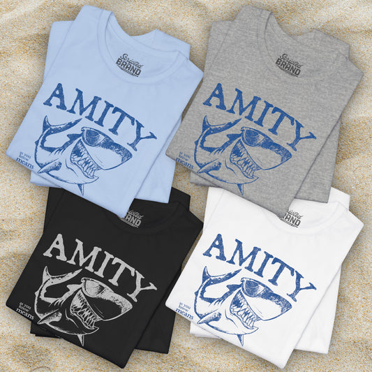 4 folded Bella+Canvas t-shirts with a vintage-style Amity Island “Friendship” shark graphic inspired by the movie Jaws