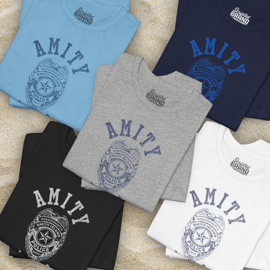 Group of 5 folded Soft unisex Bella+Canvas 3001 short-sleeve t-shirt featuring an Amity Island Police logo graphic, designed by ScriptedBrand, and  inspired by the movie Jaws in a vintage distressed style.