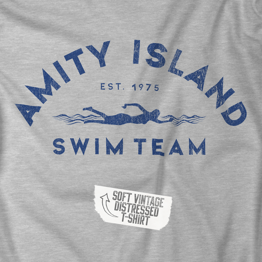 Closeup view of an Athletic Heather Grey colored Soft unisex Bella+Canvas 3001 short-sleeve t-shirt featuring an Amity Island Swim Team logo graphic, designed by ScriptedBrand, and  inspired by the movie Jaws in a vintage distressed style.